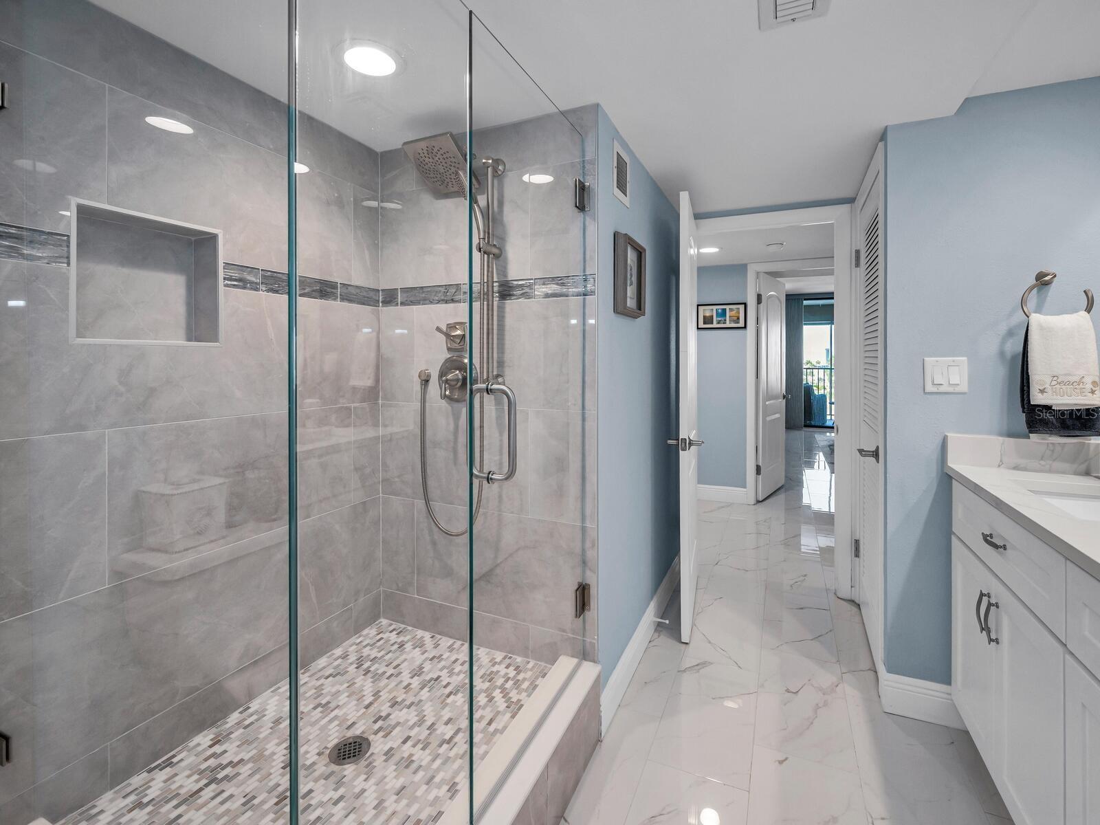 Modern baths that boast a relaxed harmony with wood cabinetry, quartz & tiled surfaces, accent fixtures and power flush efficient toilets.