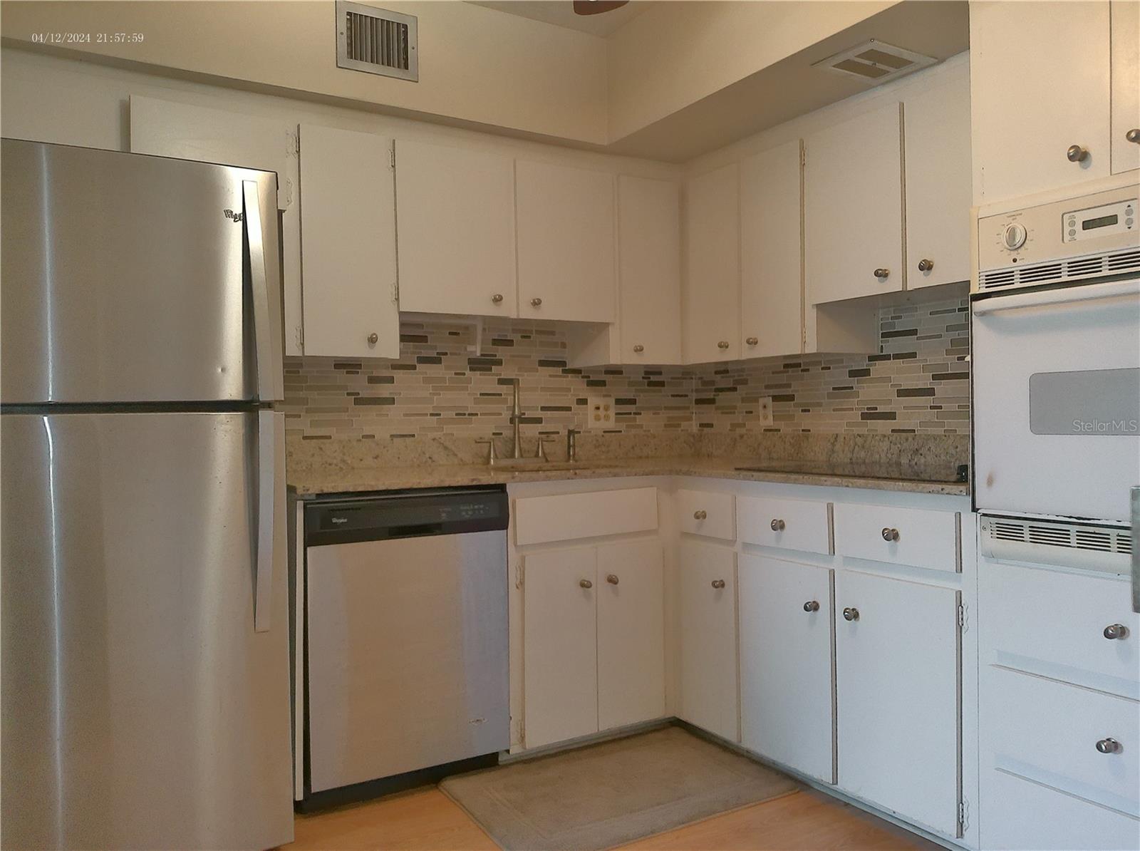 Granite countertops and a glass tile backsplash.