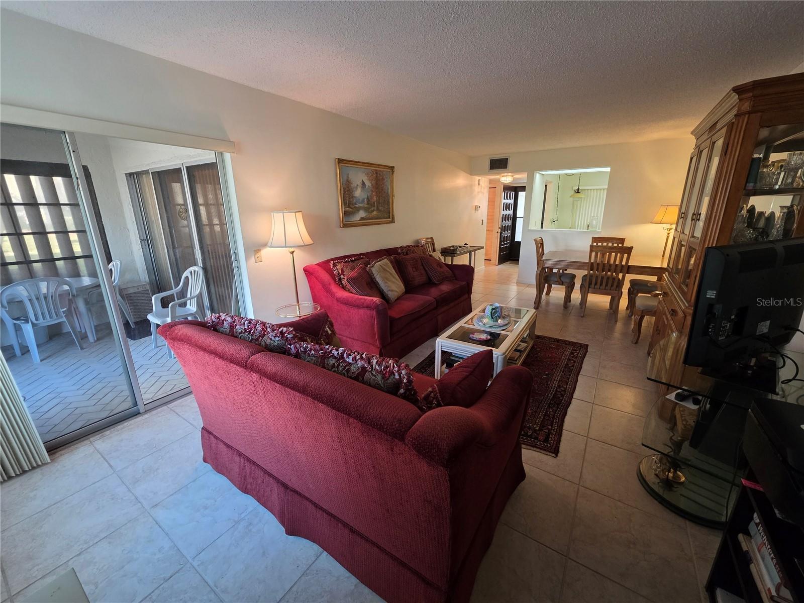 Looking to the left is your enclosed porch opening to a nice outside area and a large open green belt. straight ahead is your front door, entry foyer and kitchen with convenient pass through to a large dining area.