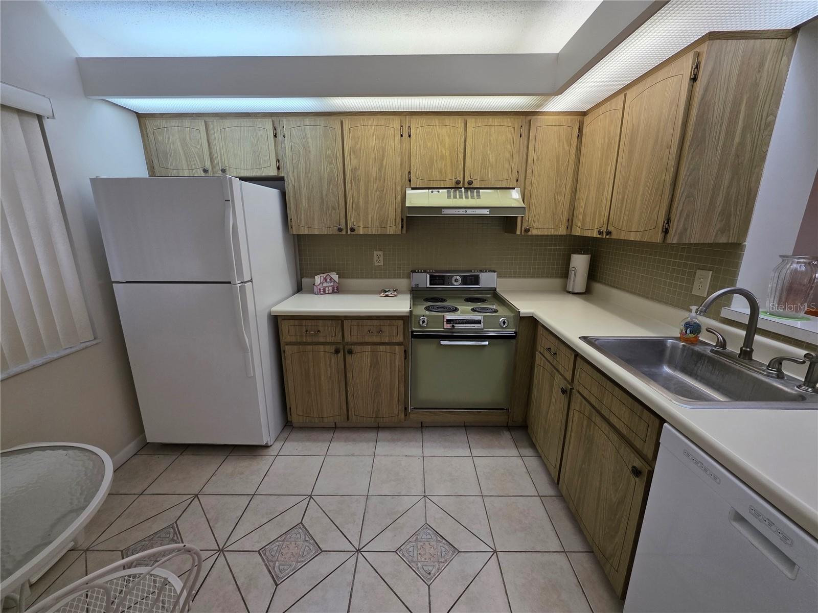 Spacious, open kitchen with refrigerator, range, hood vent, and dishwasher!
