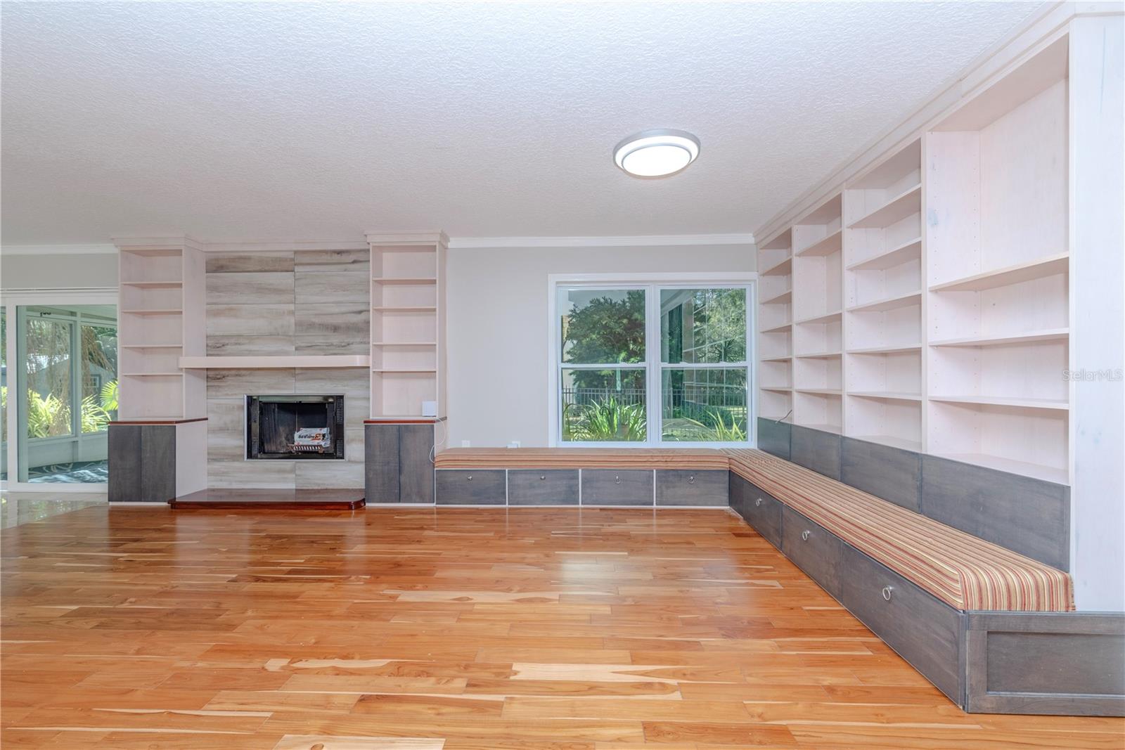 Family room with fireplace, built-in shelving, and banquette seating.