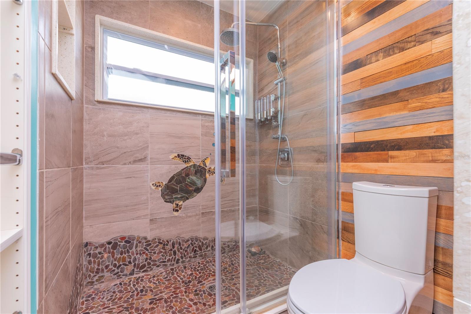 Primary bathroom with custom walk-in shower and turtle inlay.