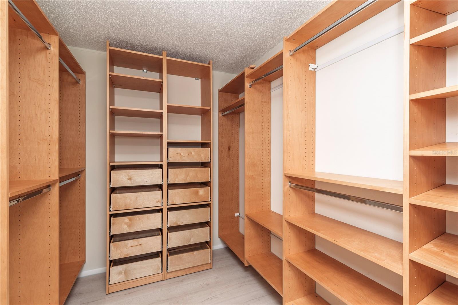 Primary bedroom walk-in closet with shelving system.