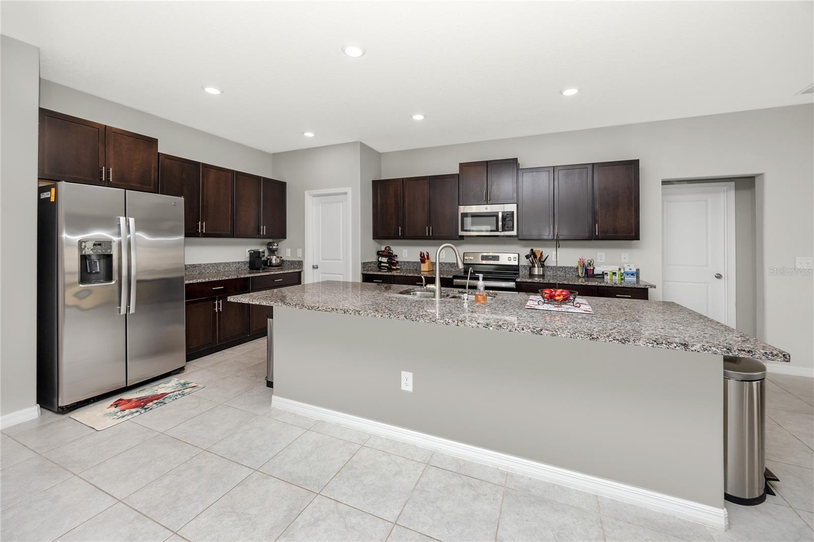 Large kitchen with expansive island, granite counters, and easy-care tile make the heart of this home!