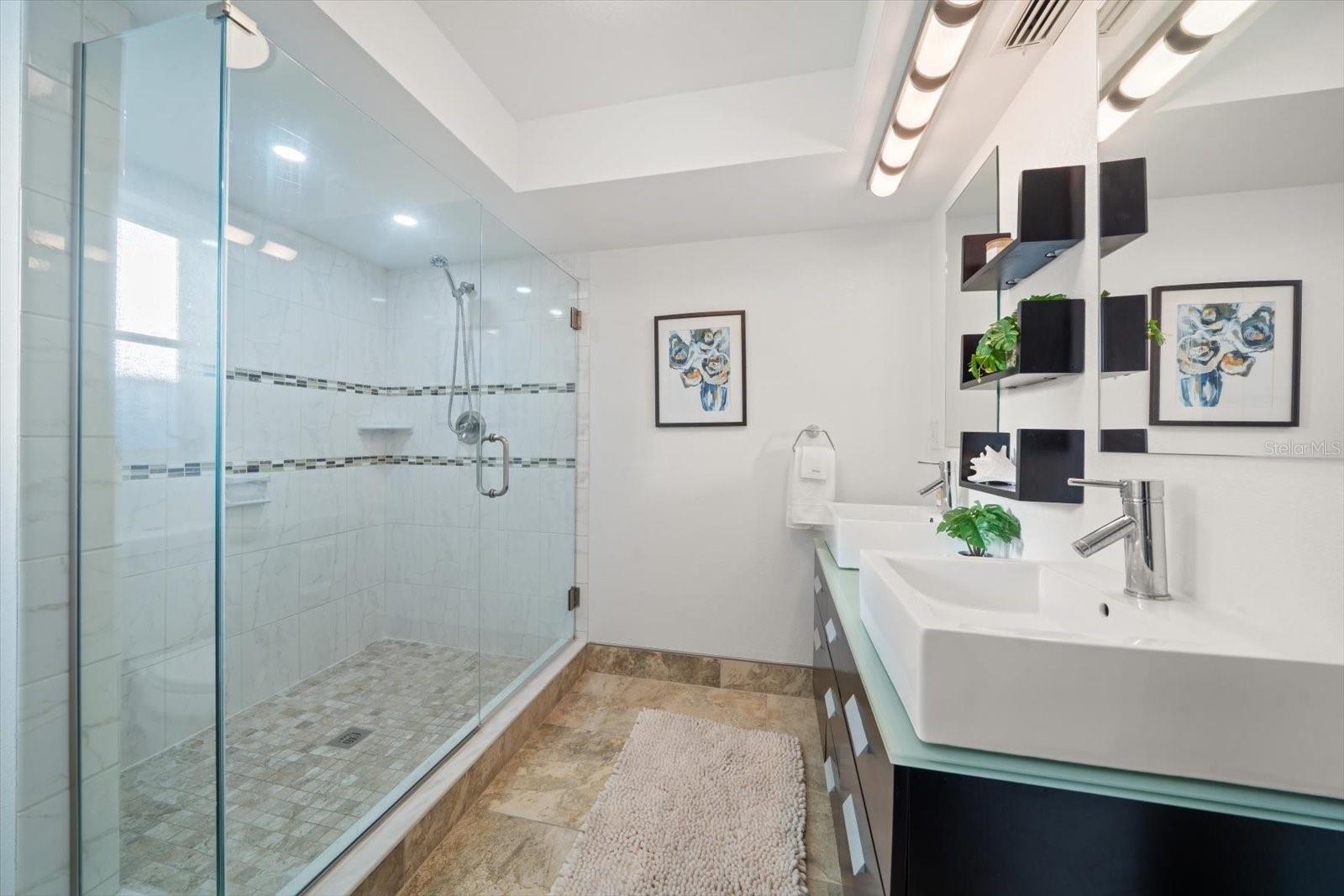 Large walk in shower with attractive tile applications.