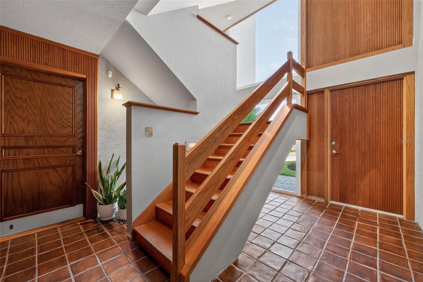 Foyer with three stories of windows and fluted wood details.