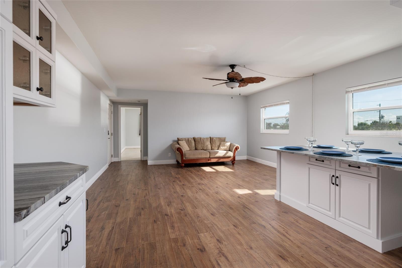 Dining/Living areas. Hurricane impact double pane windows. Doorway to primary bedroom.