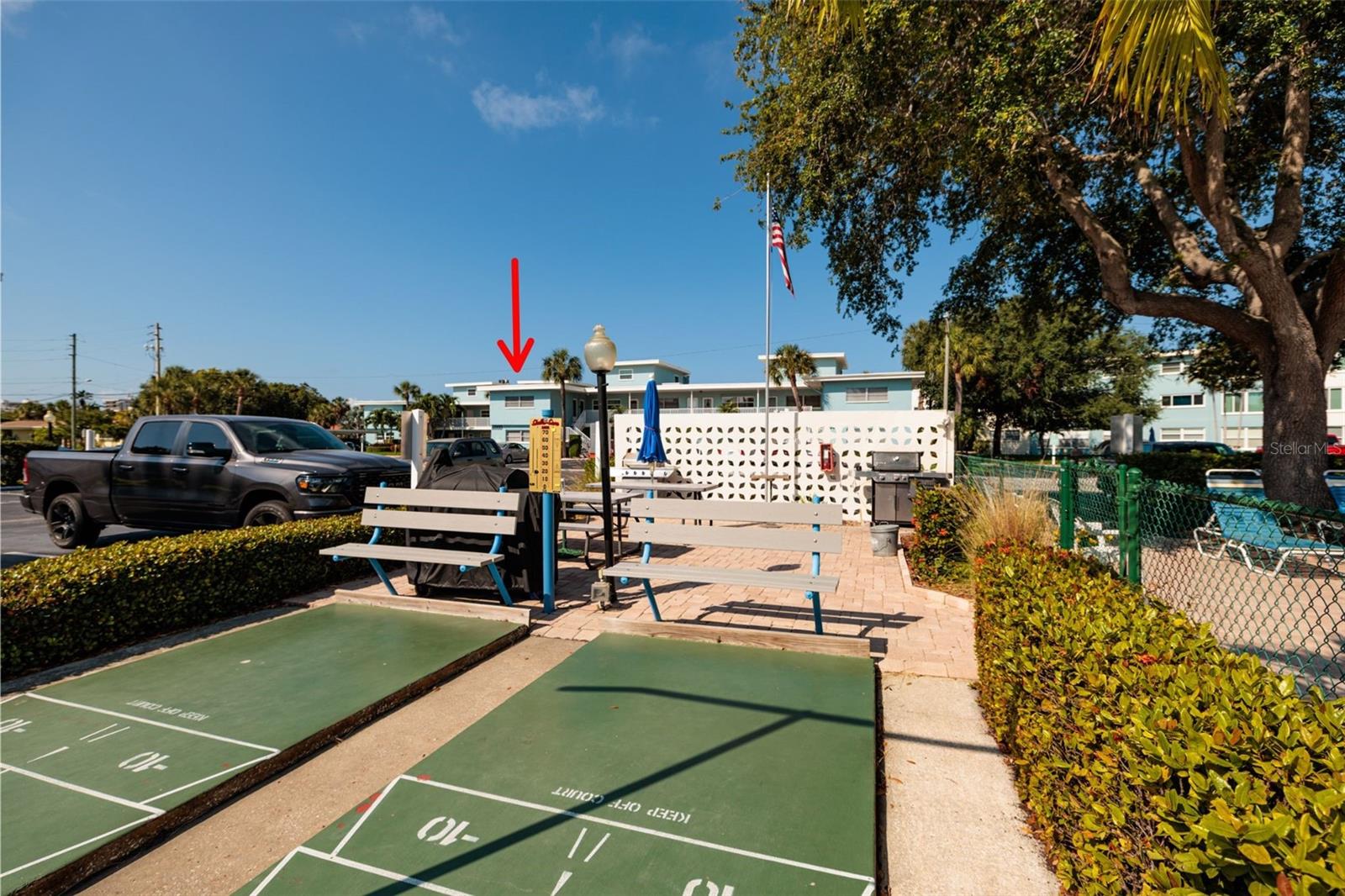 Grilling area 1 w/shuffleboard courts & pool across street from the unit.