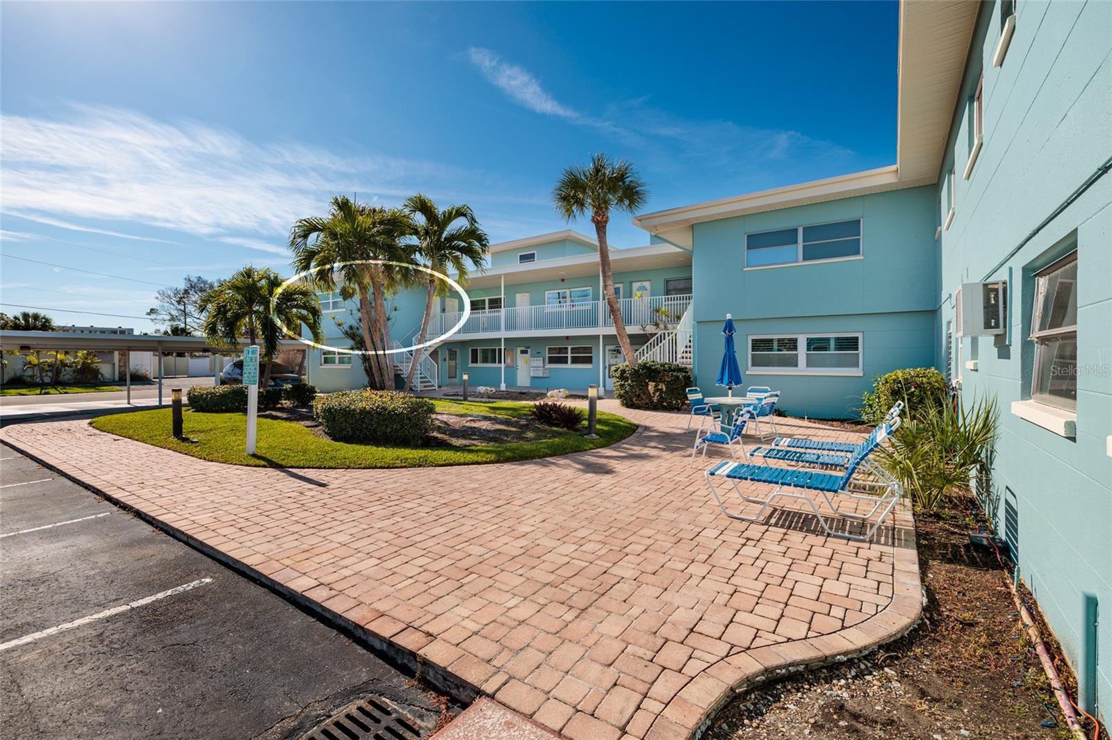 Unit 6 & courtyard. Laundry/storage room is to the right of the table w/umbrella.