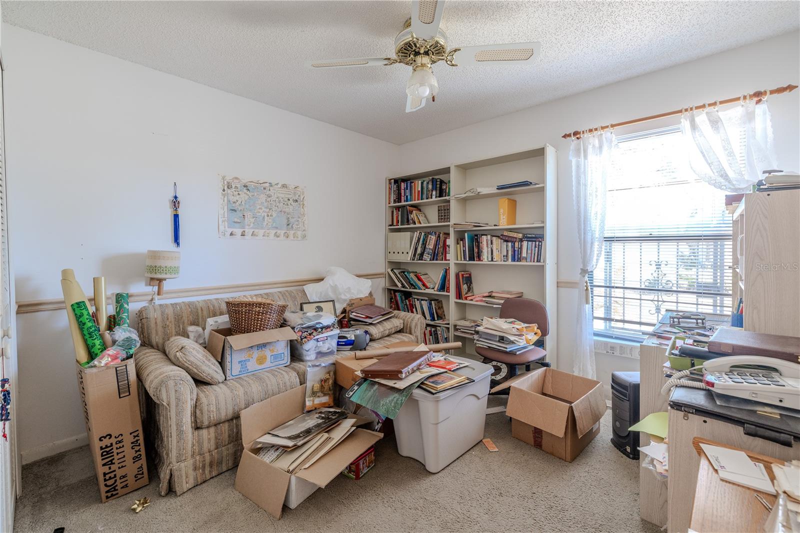 Versatile second 13.7X11.10 carpeted bedroom with a chair rail, ceiling fan, natural light, and built-in closest—also ideal for a home office, library, or guest space.
