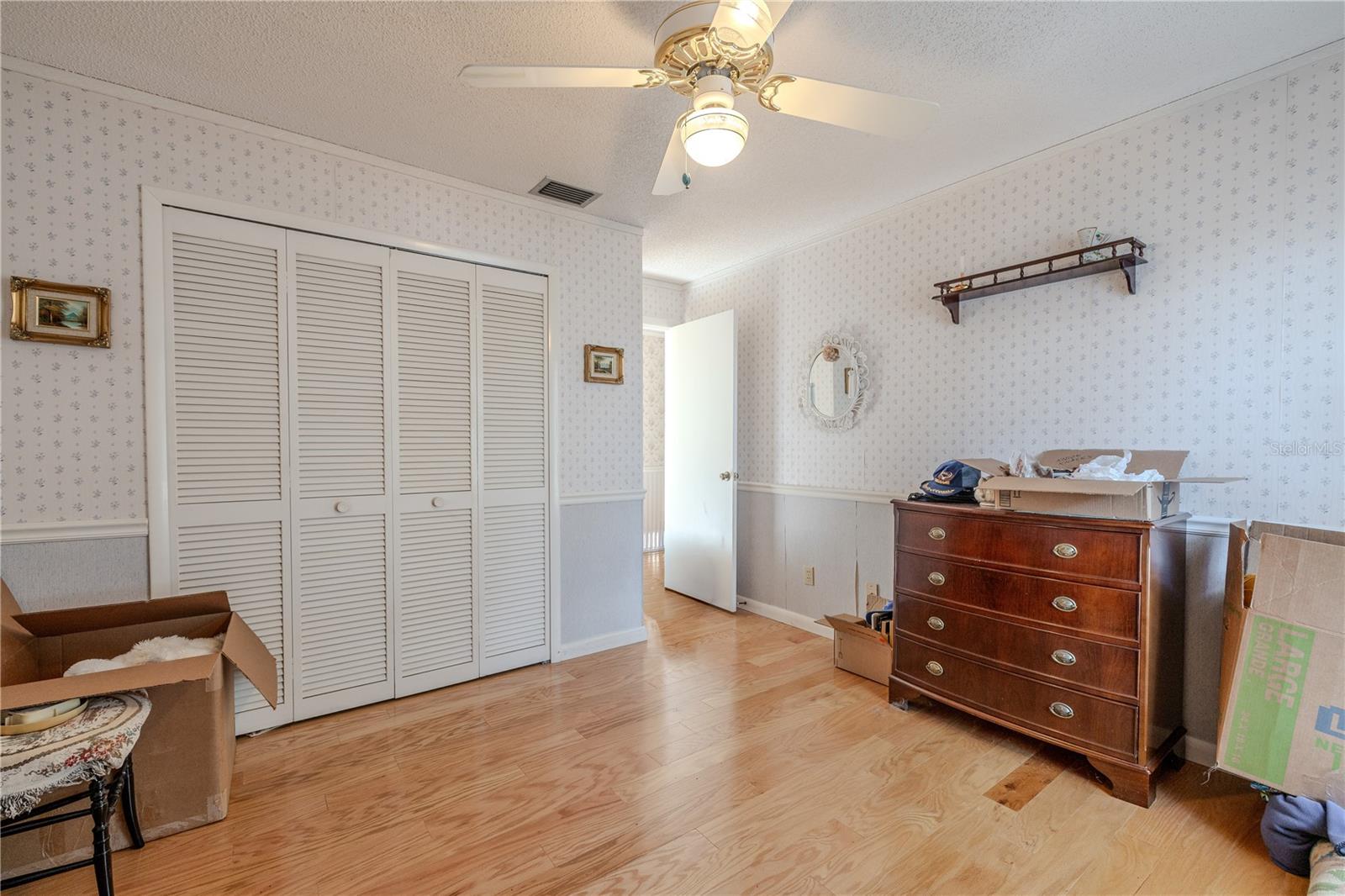 Additional view of 3rd light-filled bedroom with hardwood floors, a ceiling fan, and spacious closet.