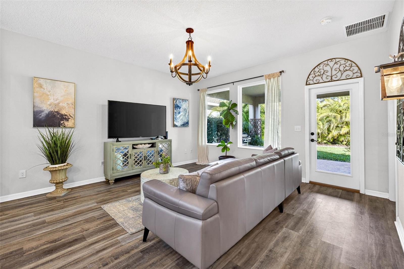 Living area with door to lanai and backyard oasis. Outlets are positioned so that tv can be hung on either wall in the living area.