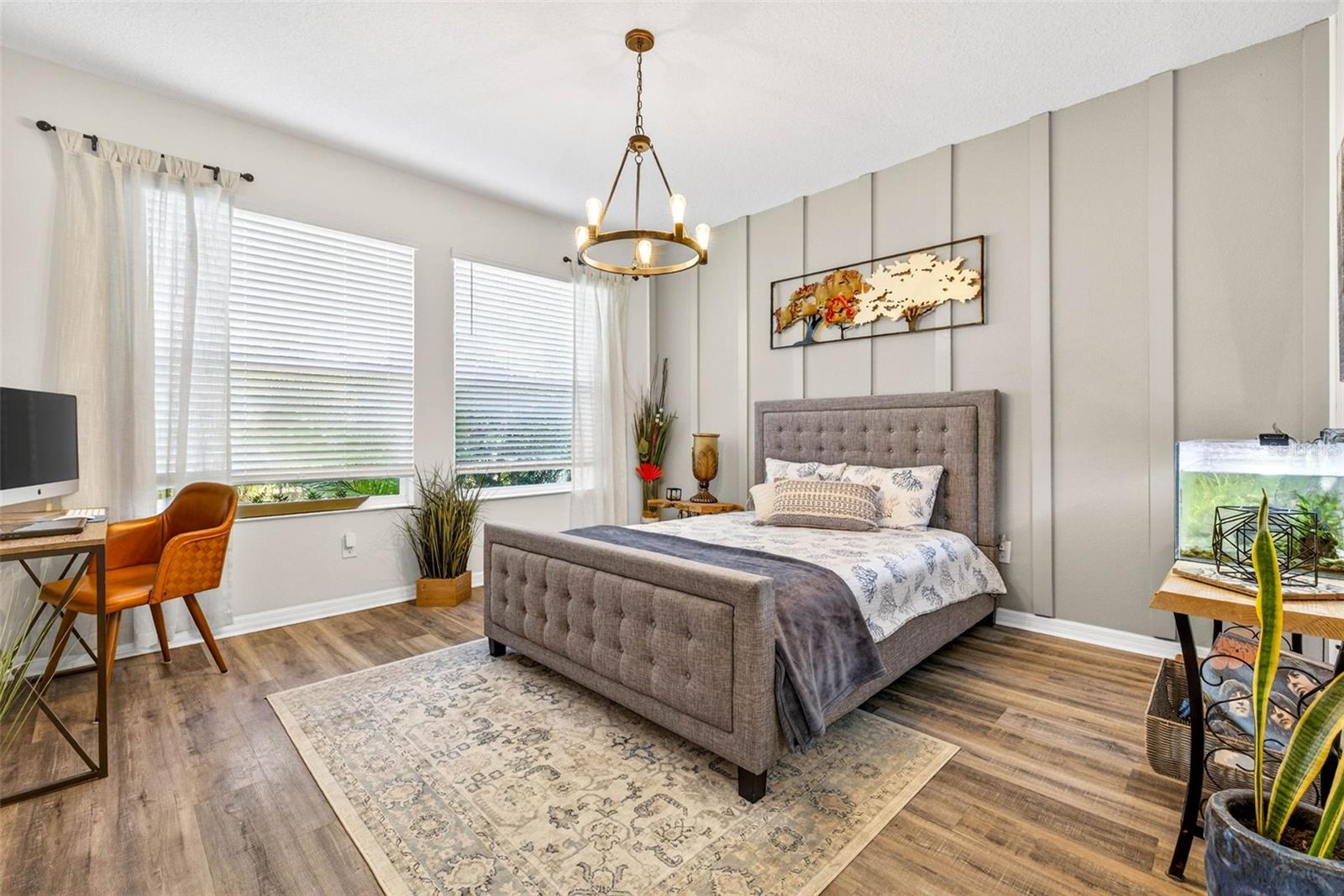 Primary bedroom located downstairs! Two large windows provide views of tropical oasis in the backyard and allow for plenty of natural light