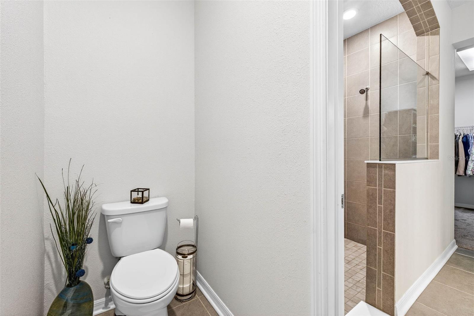 Private, oversized wash closet is located adjacent to the walk in shower.