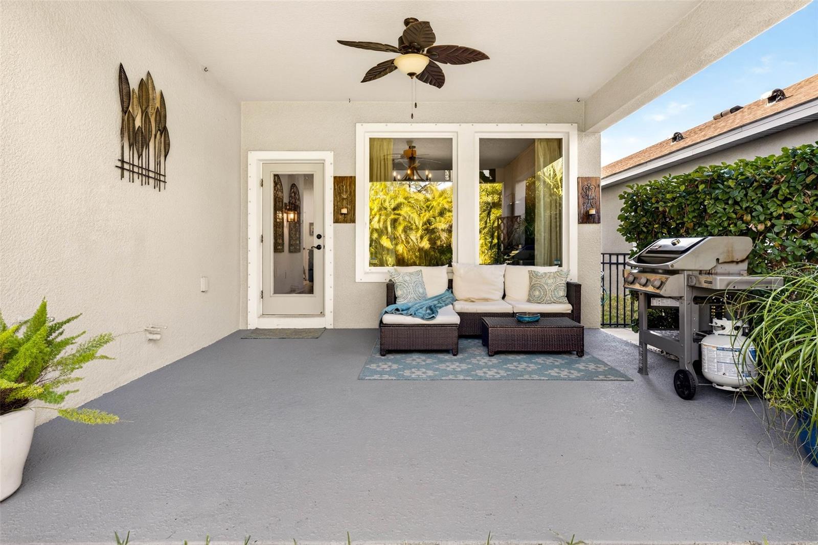 Covered lanai with painted concrete and ceiling fan. Area is fitted for an outdoor kitchen with a gas line as well as plumbing.