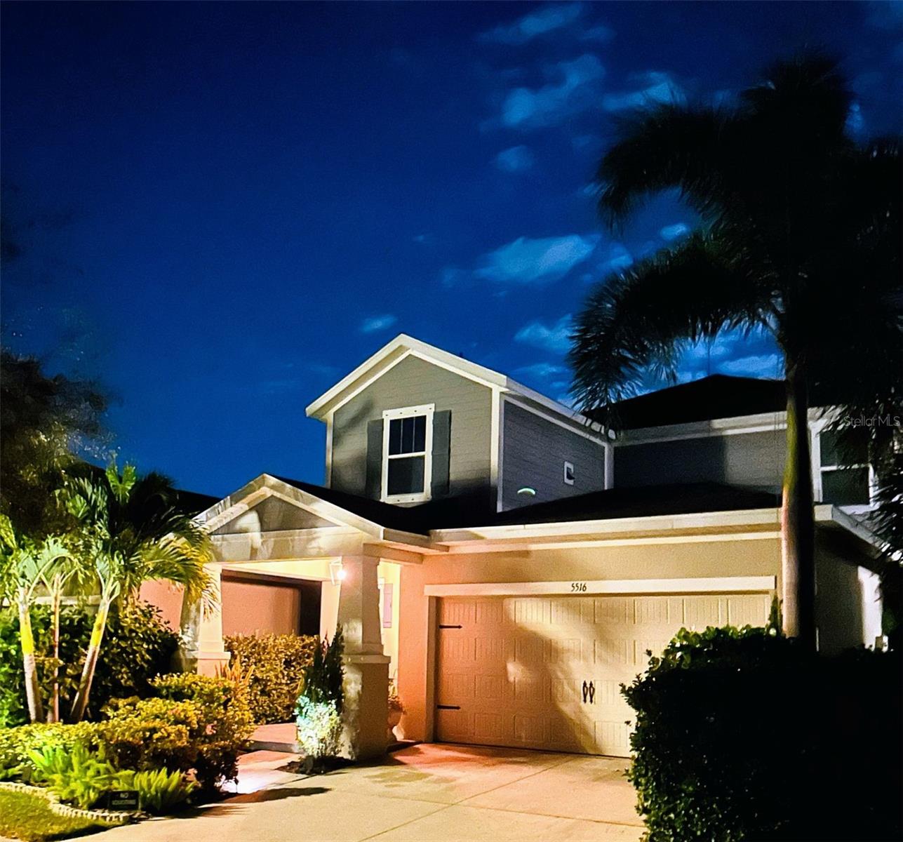 Front exterior of home at night with uplighting