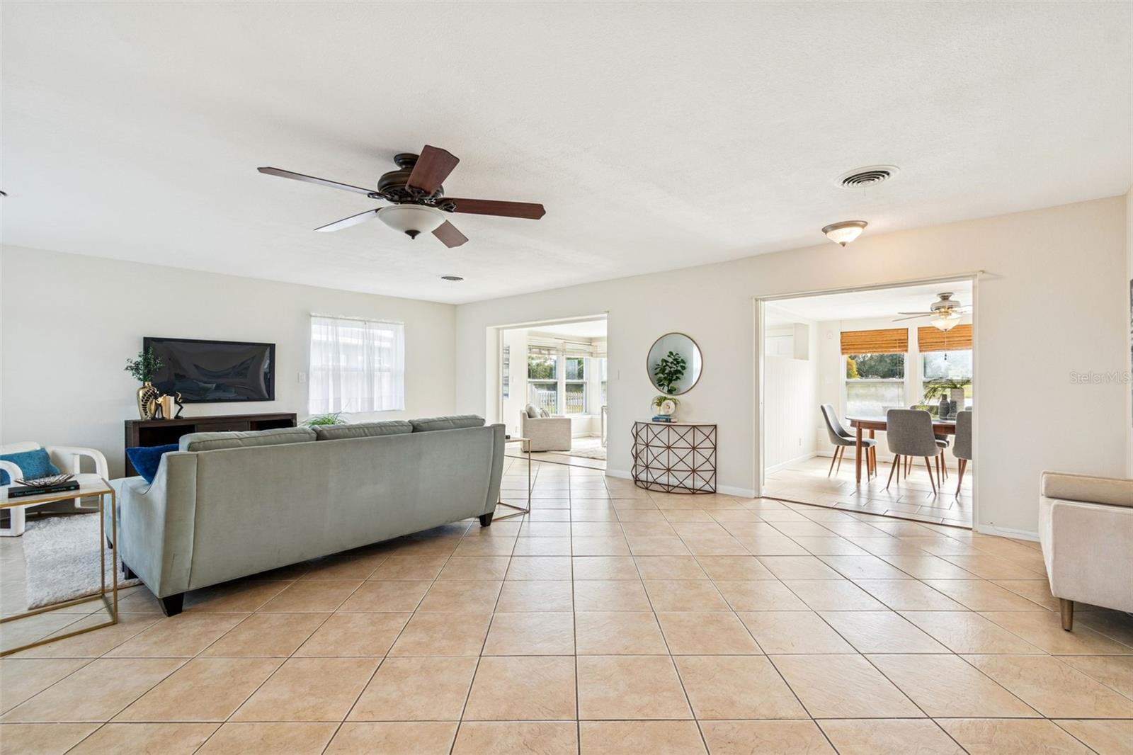 Open living room connects to 2 additional living spaces and kitchen