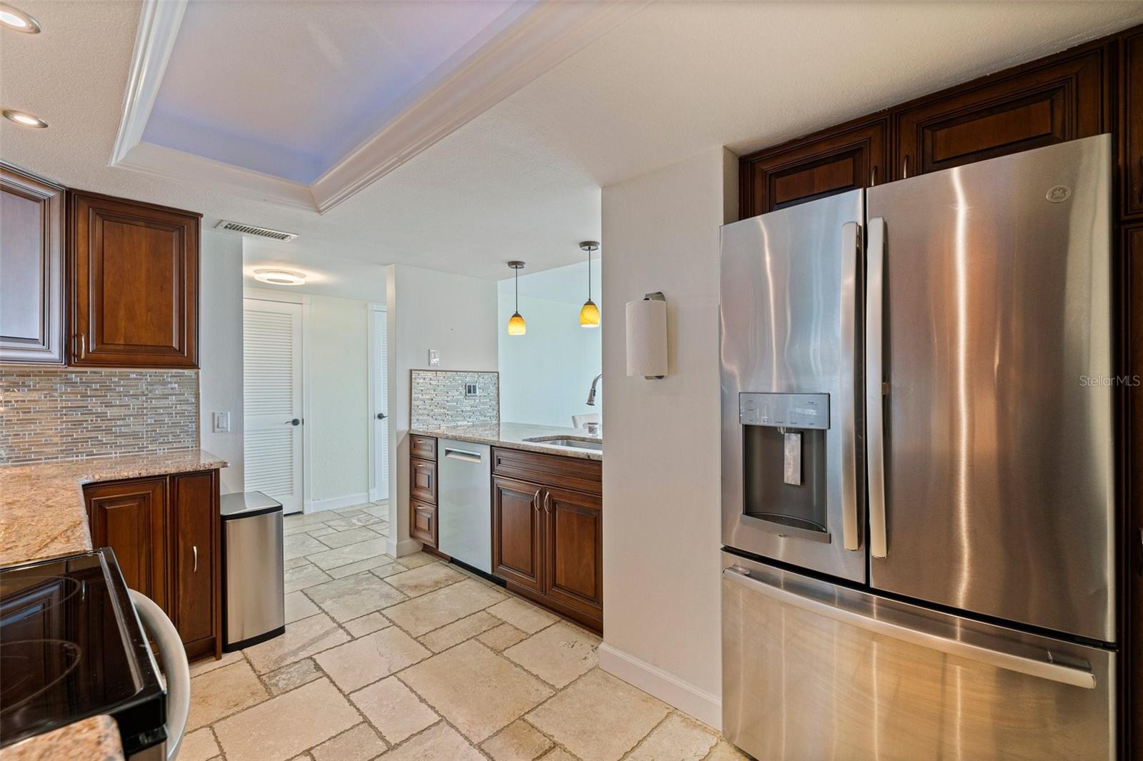 KITCHEN  AND THE ENTRANCE TO THE ADJACENT LAUNDRY ROOM WITH A FULL SIZE WASHER AND DRYER