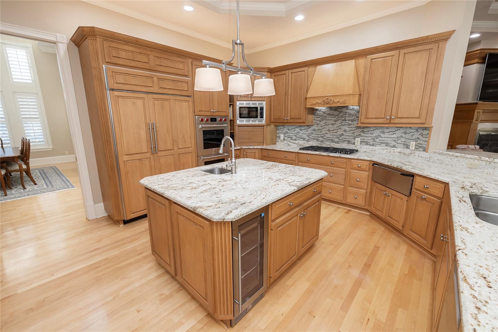 Cabinet front Sub Zero refrigerator, beverage refrigerator in island, double ovens and Wolf cooktop. Walk-in pantry in kitchen.