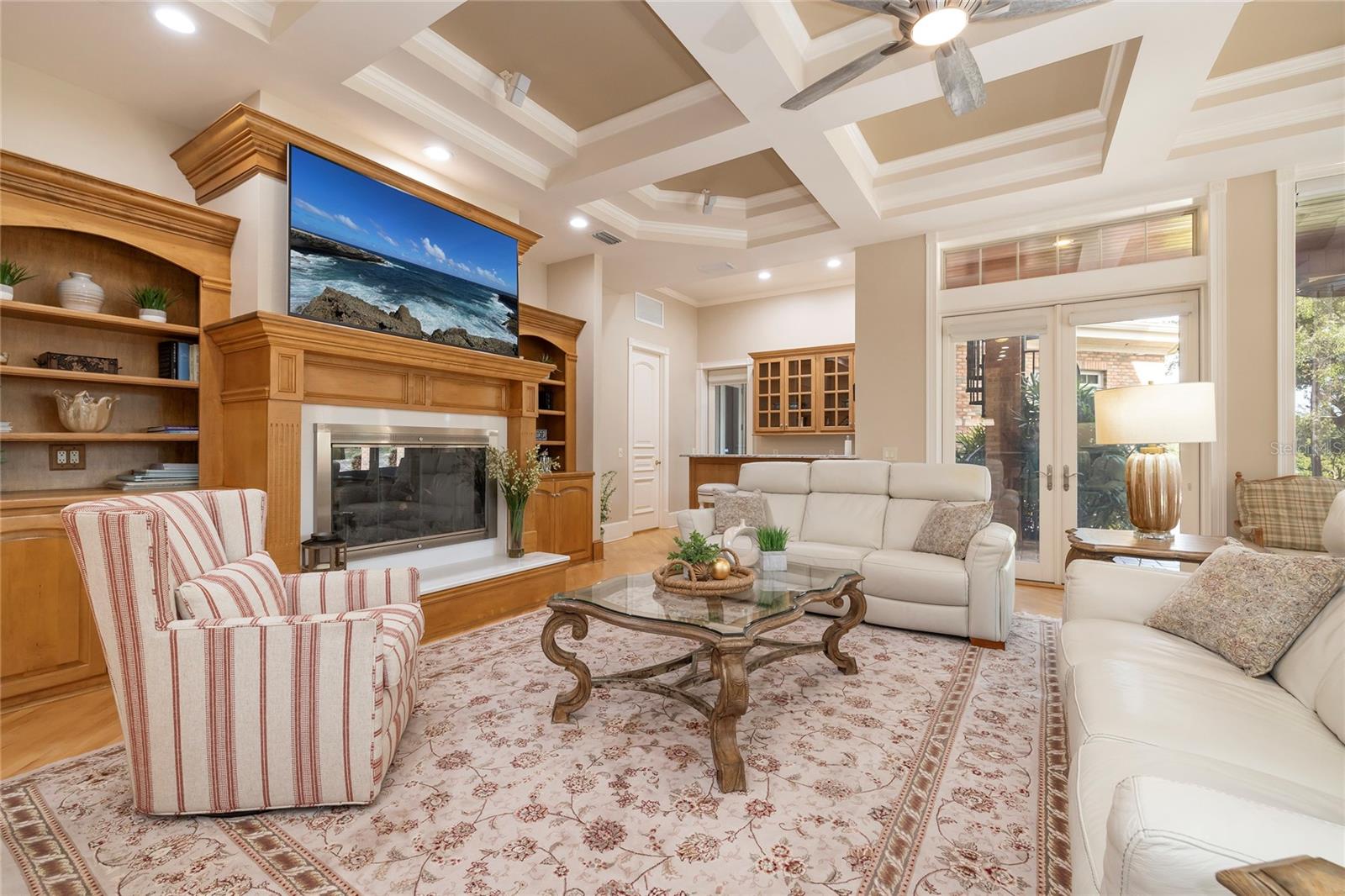 The family room has a natural gas fireplace, a wet bar with an ice machine and mini frig, and a built-in closet office. Architectural details include a box tray ceiling with crown molding.