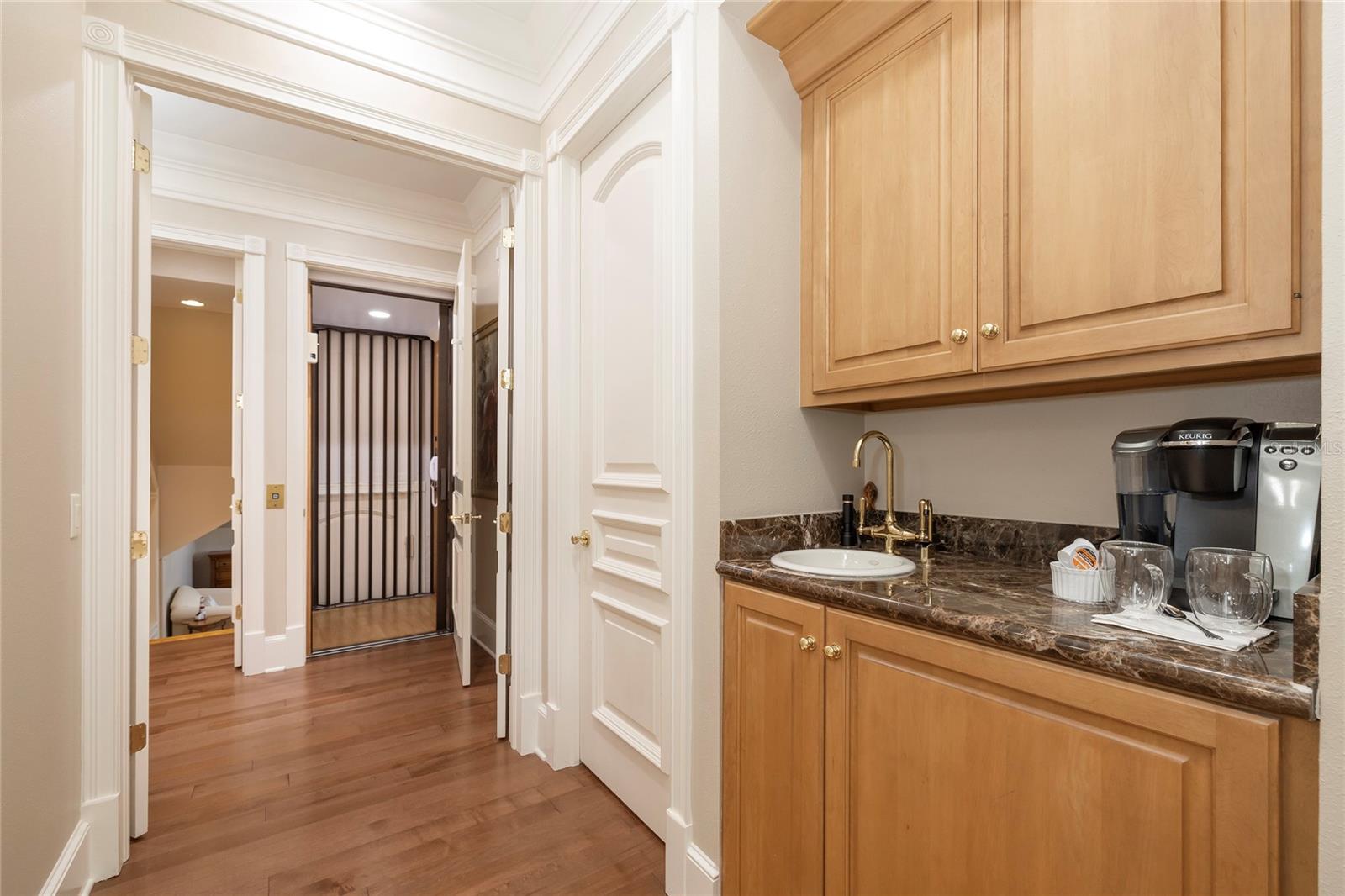 Coffee station at entrance to the Primary suite.  The elevator can be seen in the background.