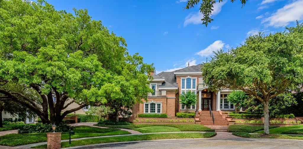 Summer photo of property showing full leaf oak tree.