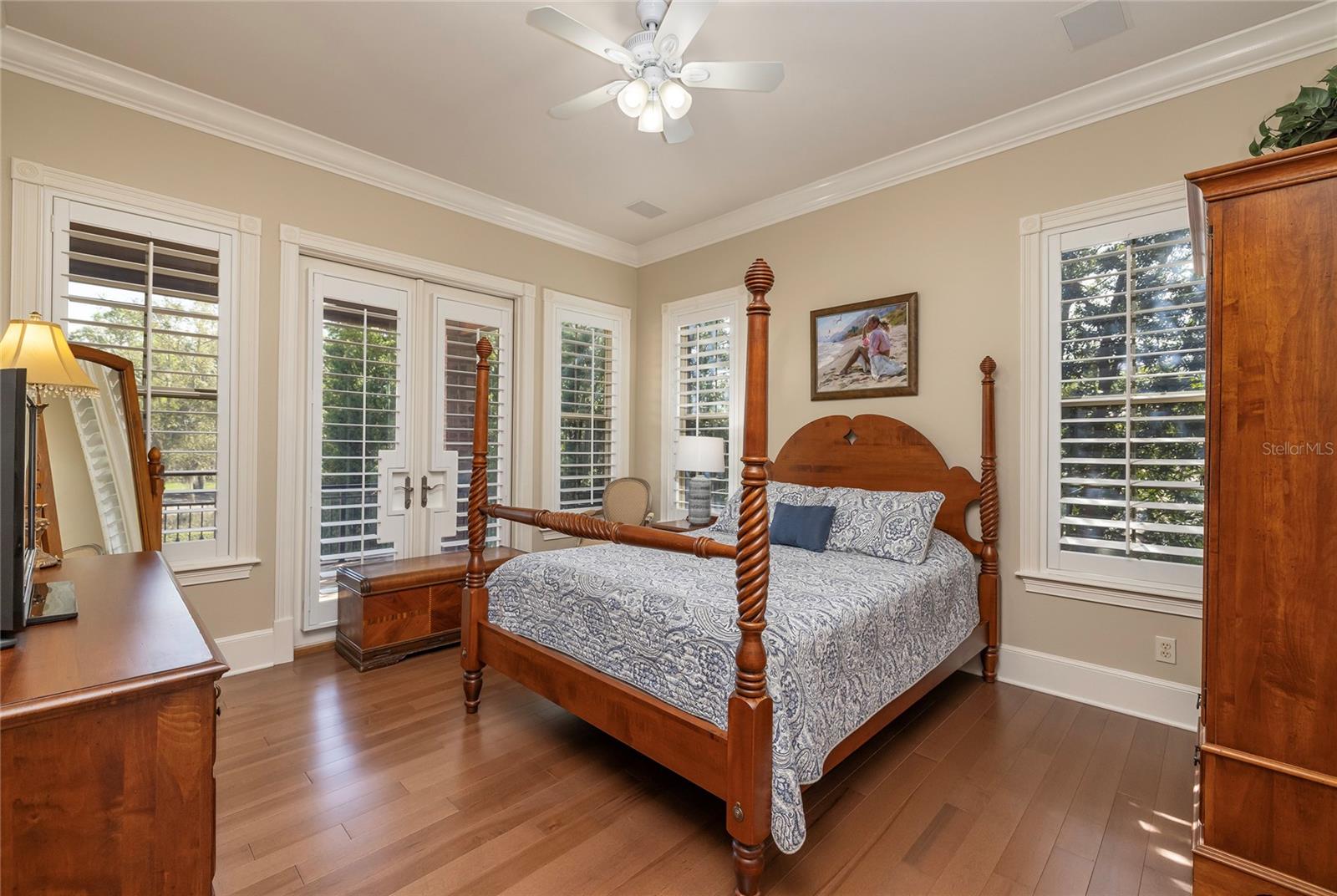 Guest bedroom with French doors to the covered balcony, walk-in closet, and ensuite bath.