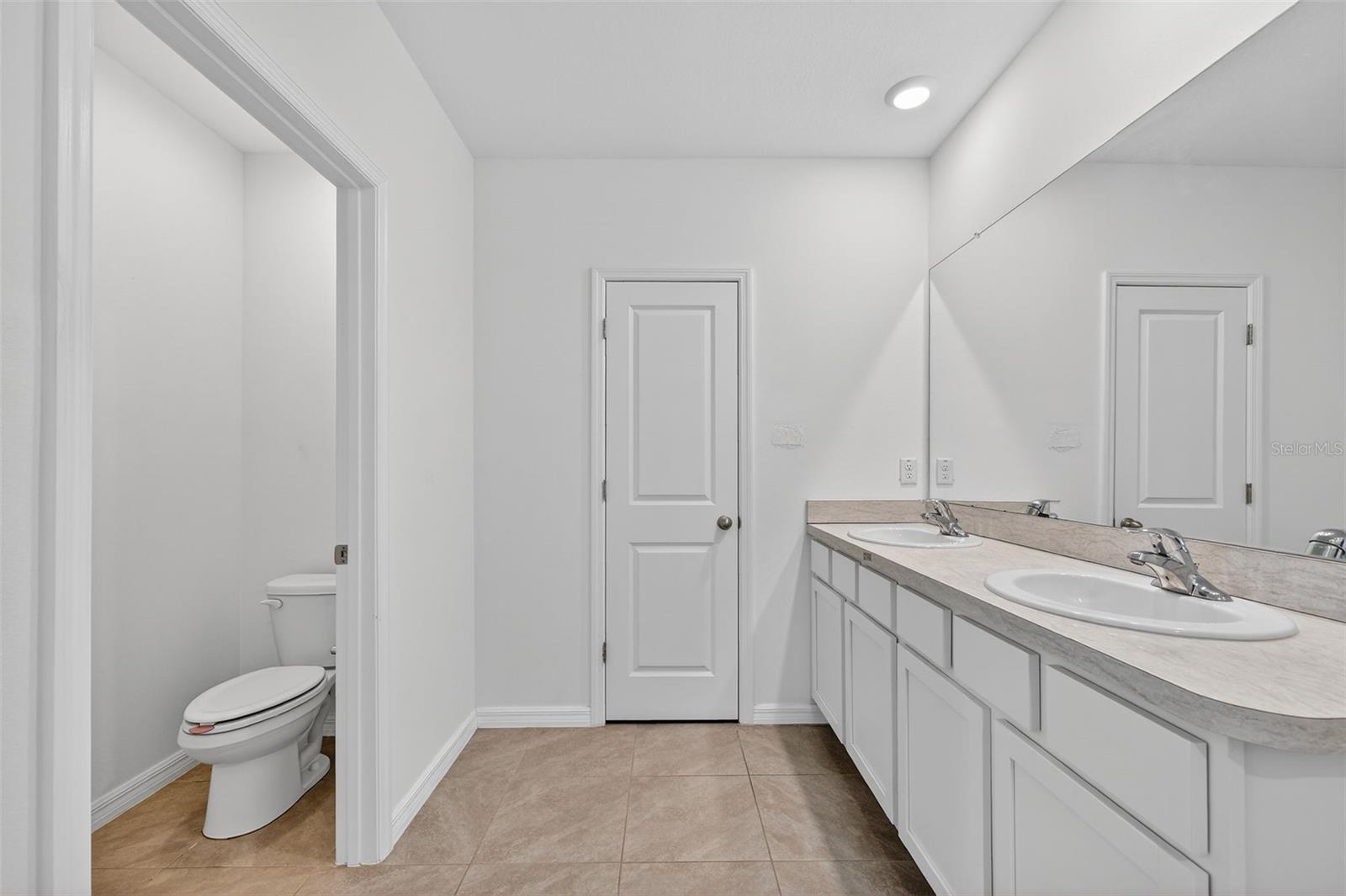 Primary Bath with private water closet and dual vanity and linen closet