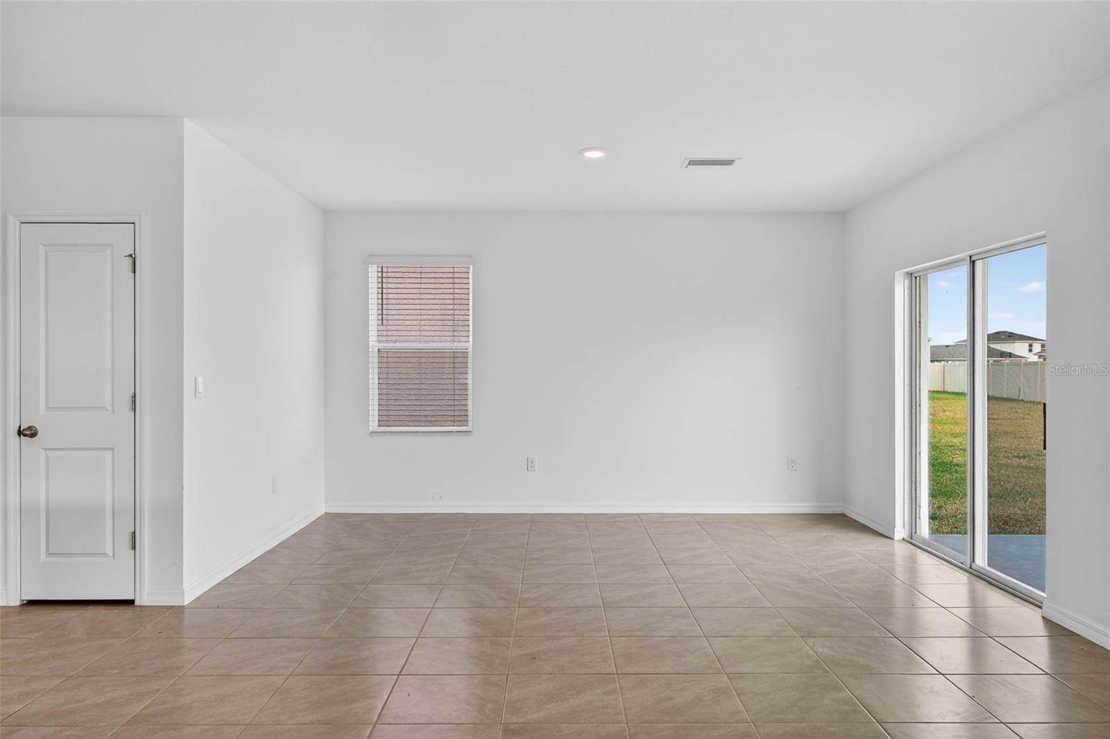 Dining Area in Great Room with Sliders to Back Yard