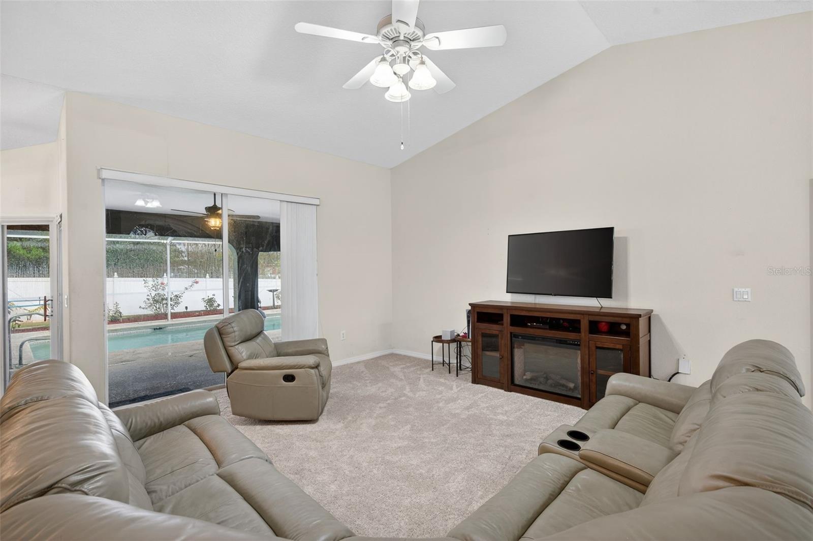 Living Room opens to Lanai and Pool area. The sliding door behind the recliner is a pocket sliding door and disappears into the wall when fully opened.