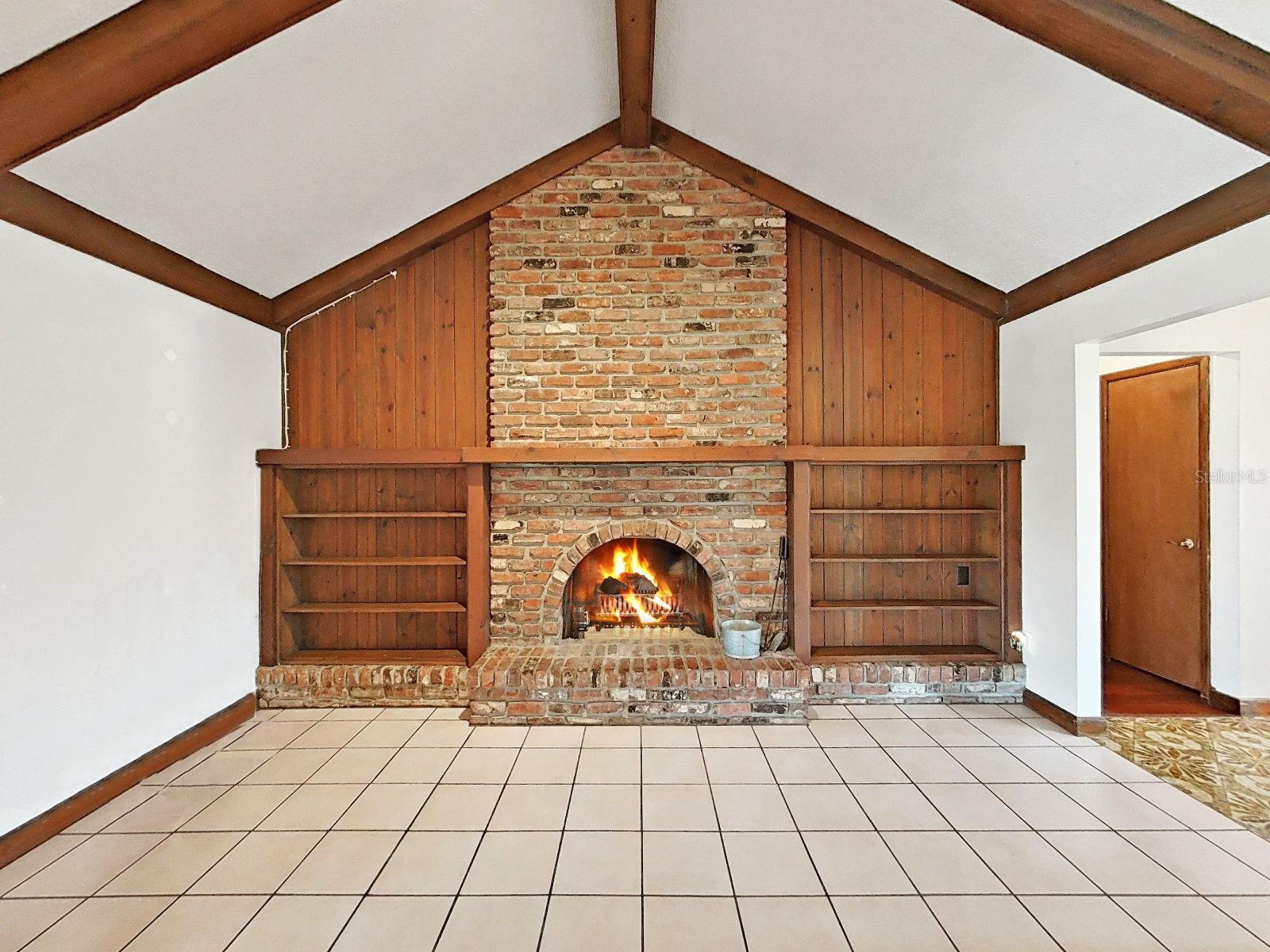 Beautiful Brick Wood Burning Fireplace with Bookshelves in the Family Room