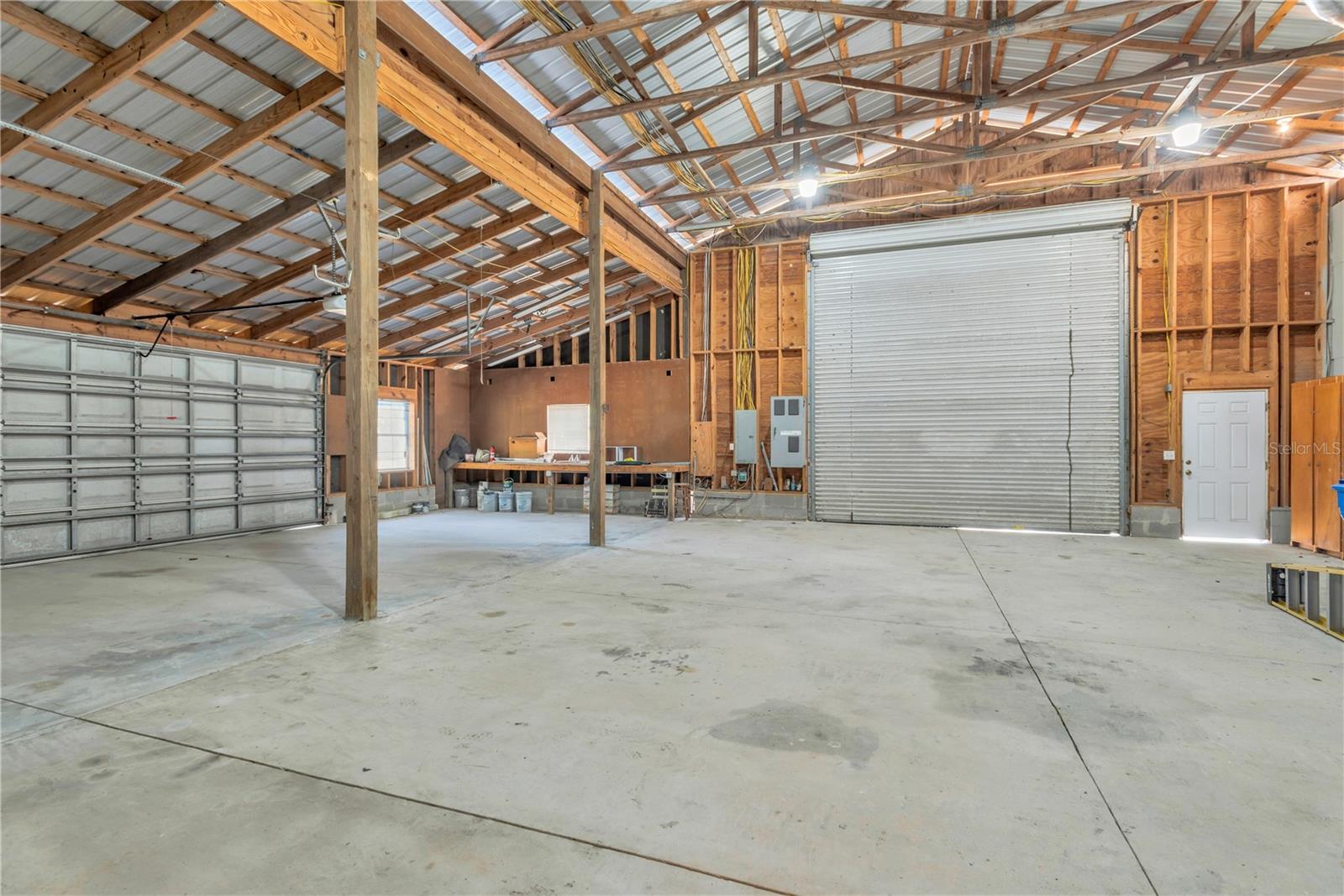 This garage has 2 separate entrances: an oversized 15-foot roll-up door for RV, boat, or large-vehicle access, and a two-car garage door with an electric opener.
