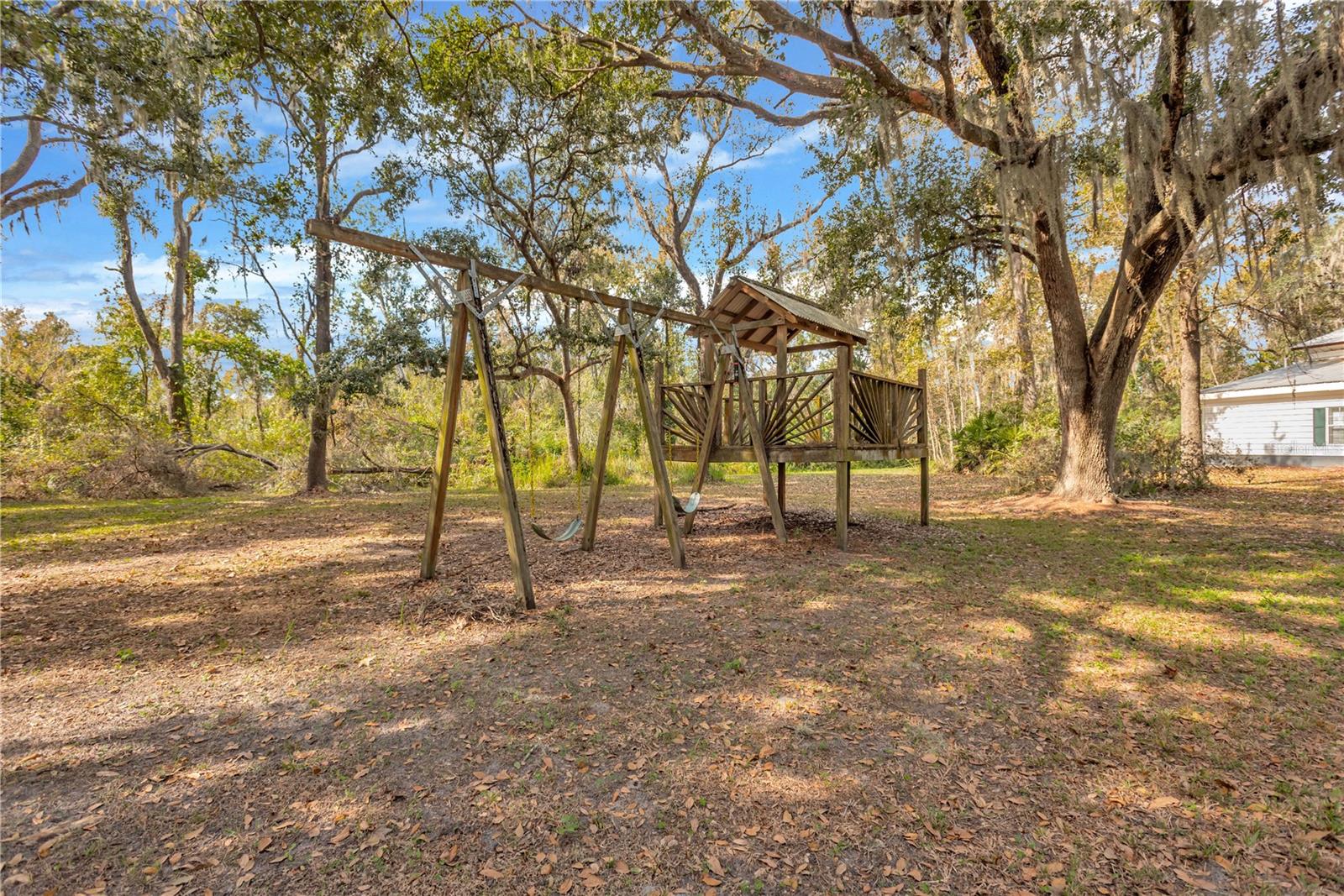 This large wooden play structure nestled under the shade trees will keep the kids busy.