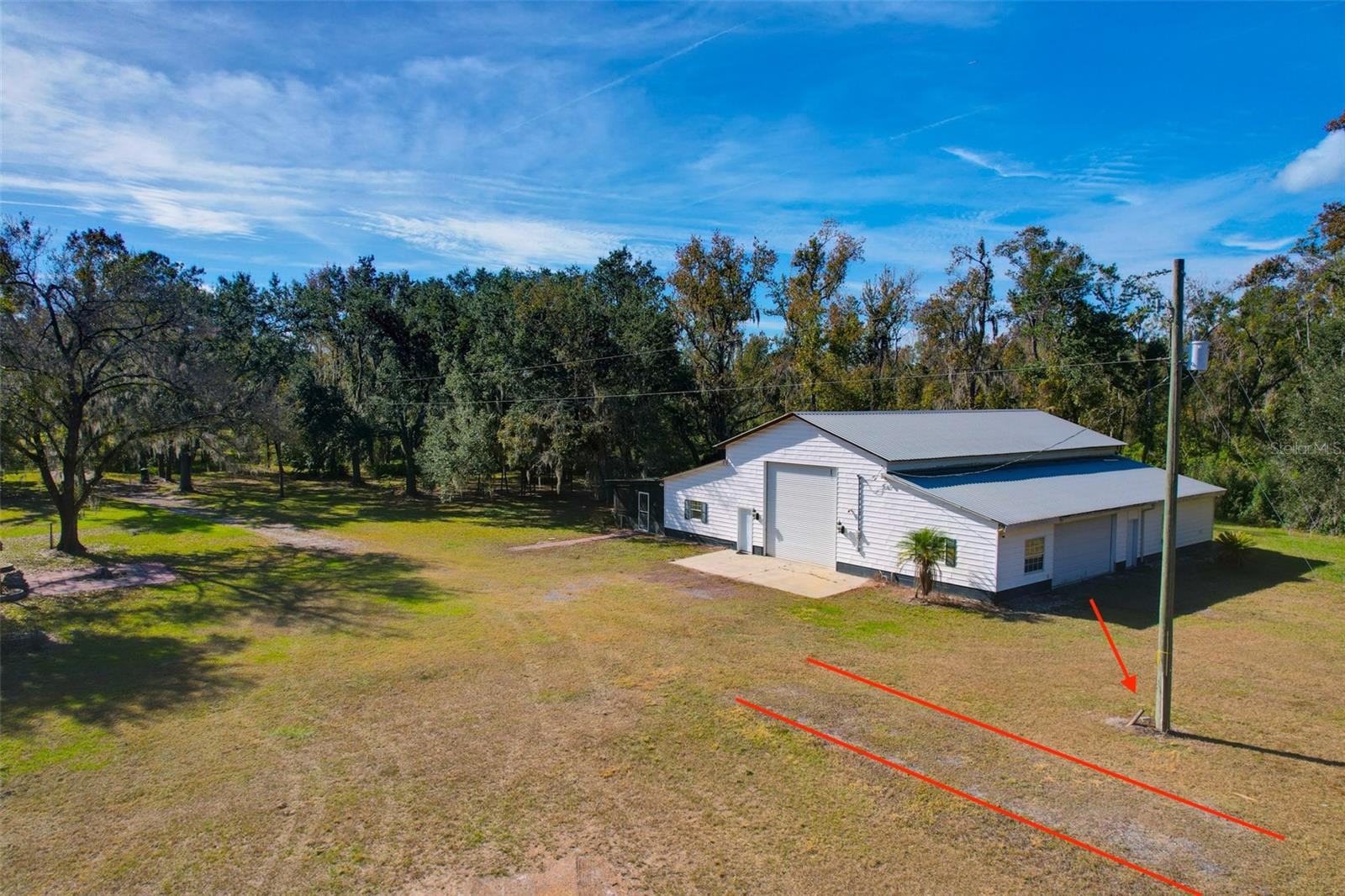 The red lines and arrow marks a dedicated mobile home pad with water and 30-amp electrical service.  Historically, There were also 2 full sized mobile homes located on the property with full water, electric, and septic service in place, showcasing the site’s potential for future multi-generational living, guest accommodations, or additional dwellings.