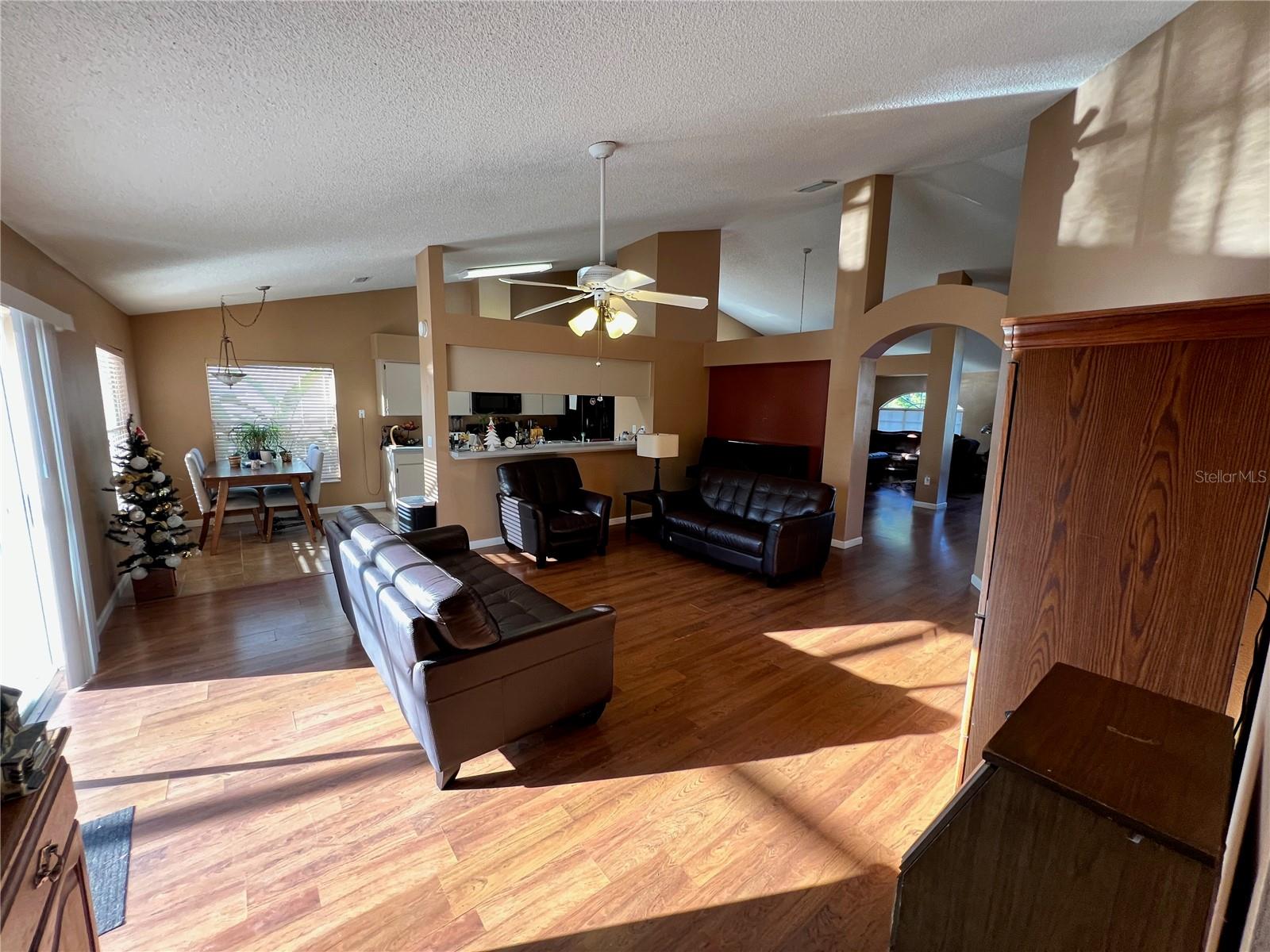 View of family room from hallway leading to second and third bedrooms, hall bath, and laundry room.