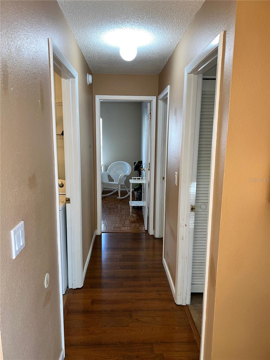 Hallway off of family room. Door on left is to laundry. Door on near right is to hall bath. Door on far right is to second bedroom. Door straight ahead is to third bedroom.