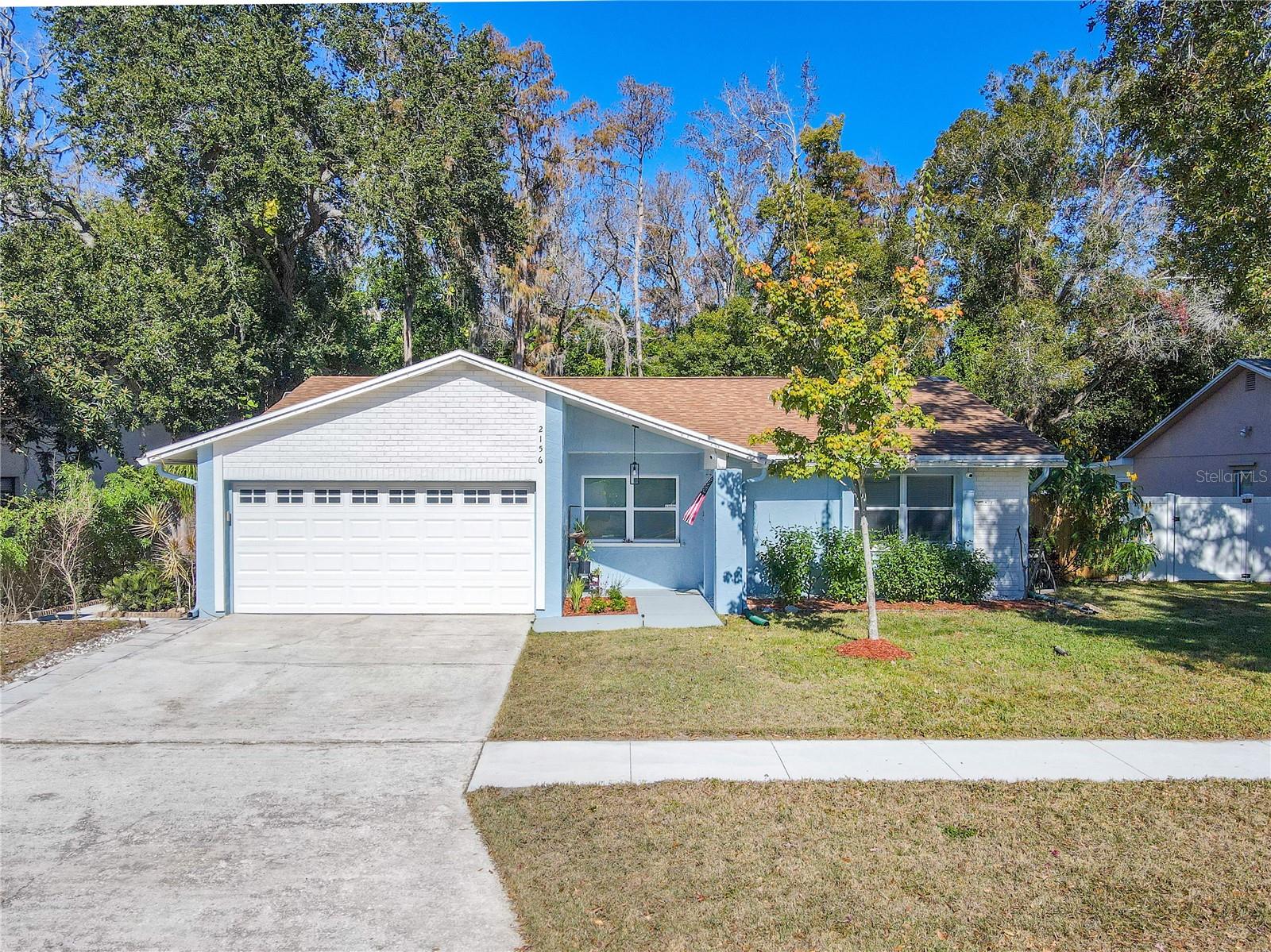 Charming 3 bedroom, two full bath single-story home with a spacious two-car garage, wide driveway, and inviting covered entry, featuring a clean, refreshed exterior and neat landscaping, with the added privacy of a lush preserve backdrop behind the home.