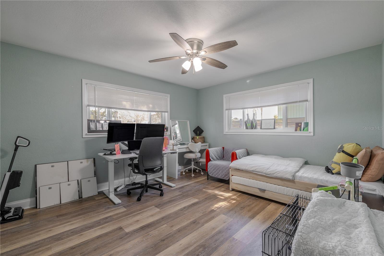 Spacious second bedroom offers wide-plank vinyl flooring, a modern ceiling fan, and plenty of natural light—ideal for a home office, guest room, or creative space.