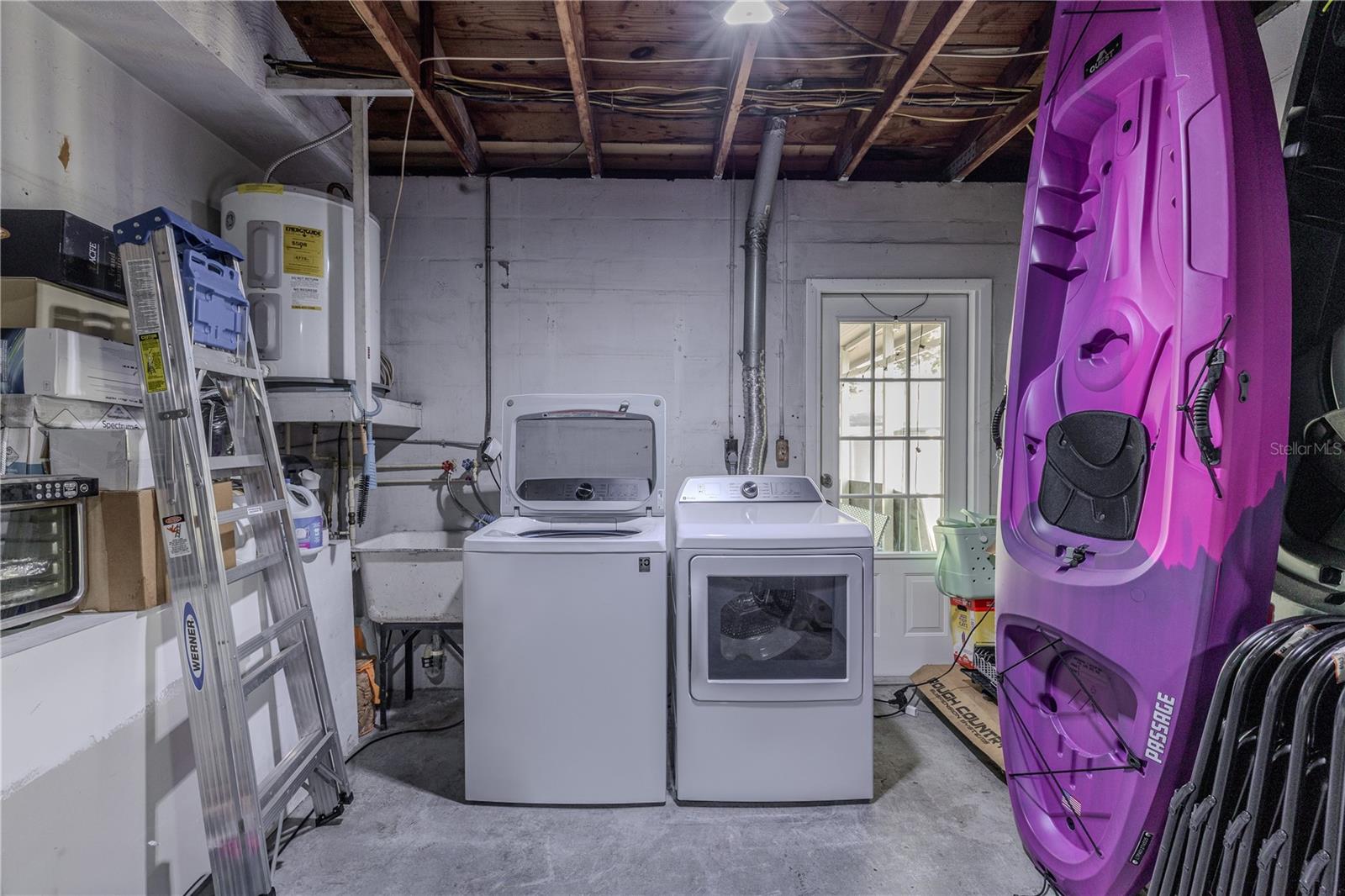 Spacious garage includes a dedicated laundry area with utility sink and extra storage space, plus convenient access to the backyard/patio.