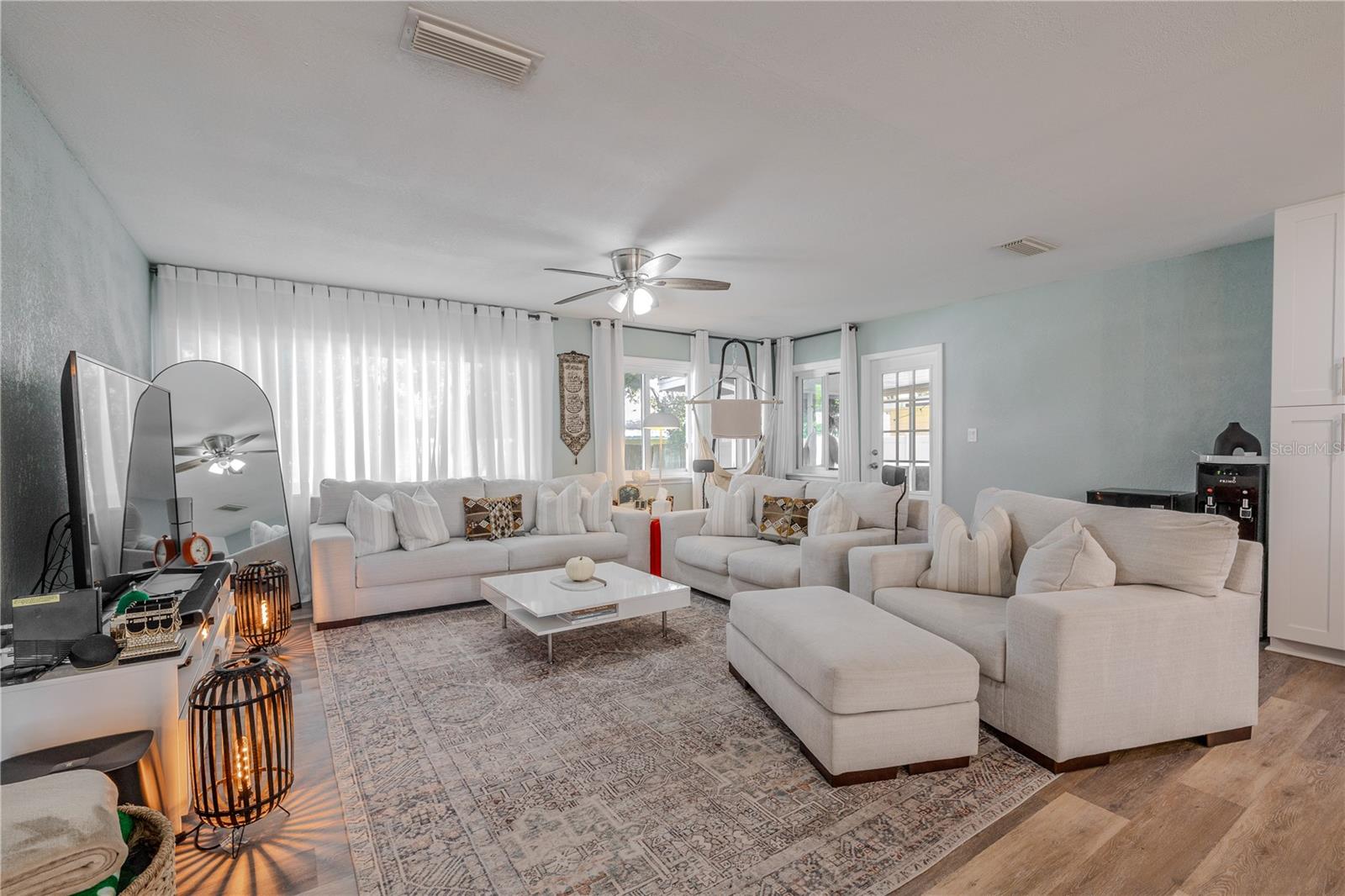 Spacious living room offers a bright, inviting retreat with wide-plank vinyl flooring, oversized windows, and a comfortable layout perfect for gathering and entertaining.