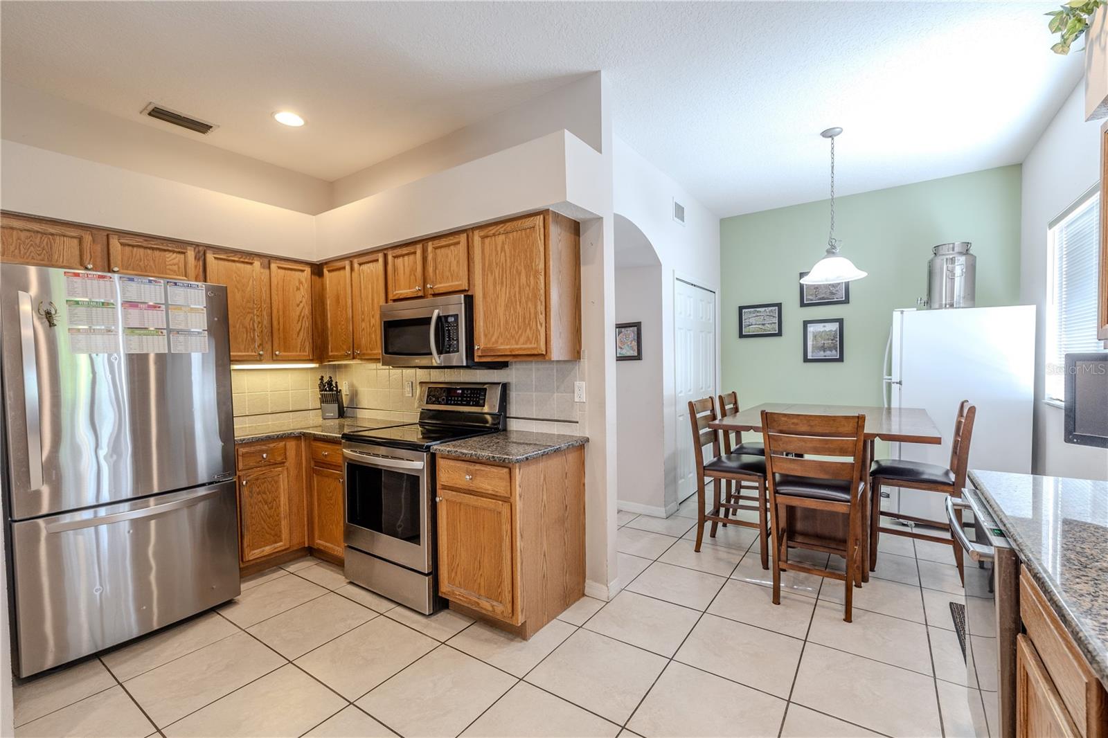 Well-appointed kitchen offers stainless appliances, granite countertops, and ample wood cabinetry, plus a bright breakfast nook for casual dining.