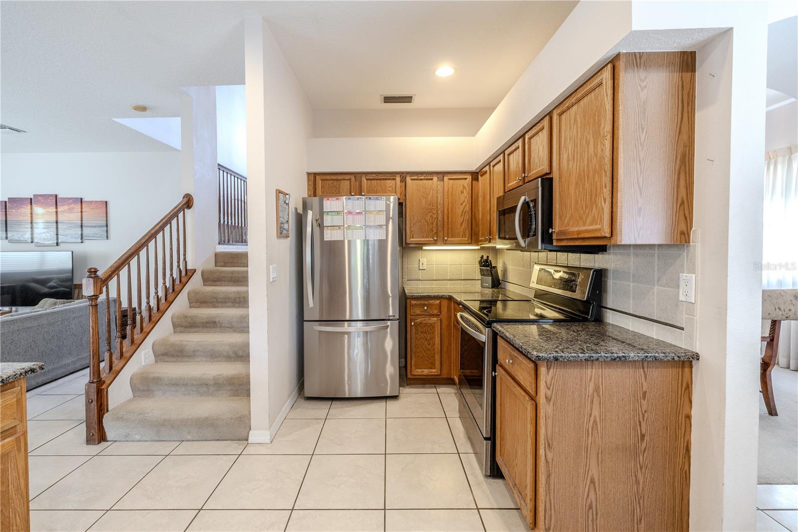 Efficient galley-style kitchen features stainless appliances, granite countertops, and abundant wood cabinetry, with easy flow to the living areas for effortless entertaining.