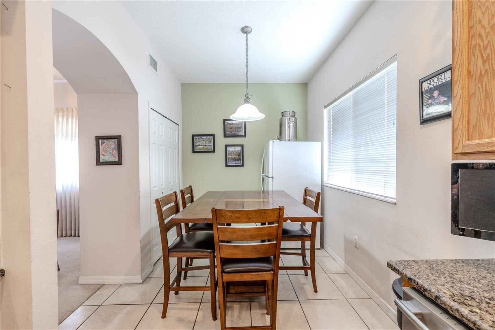 Bright eat-in breakfast nook offers a comfortable dining space with a large window, pendant lighting, and easy flow to the kitchen and living areas.