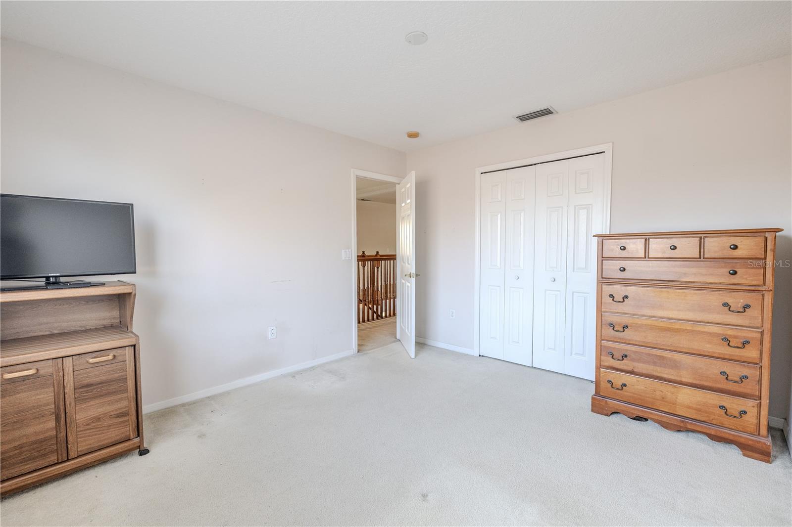 Fourth bedroom offers a generous layout with plush carpeting and a large double-door closet, perfect for guests, a home office, or a flexible bonus space.