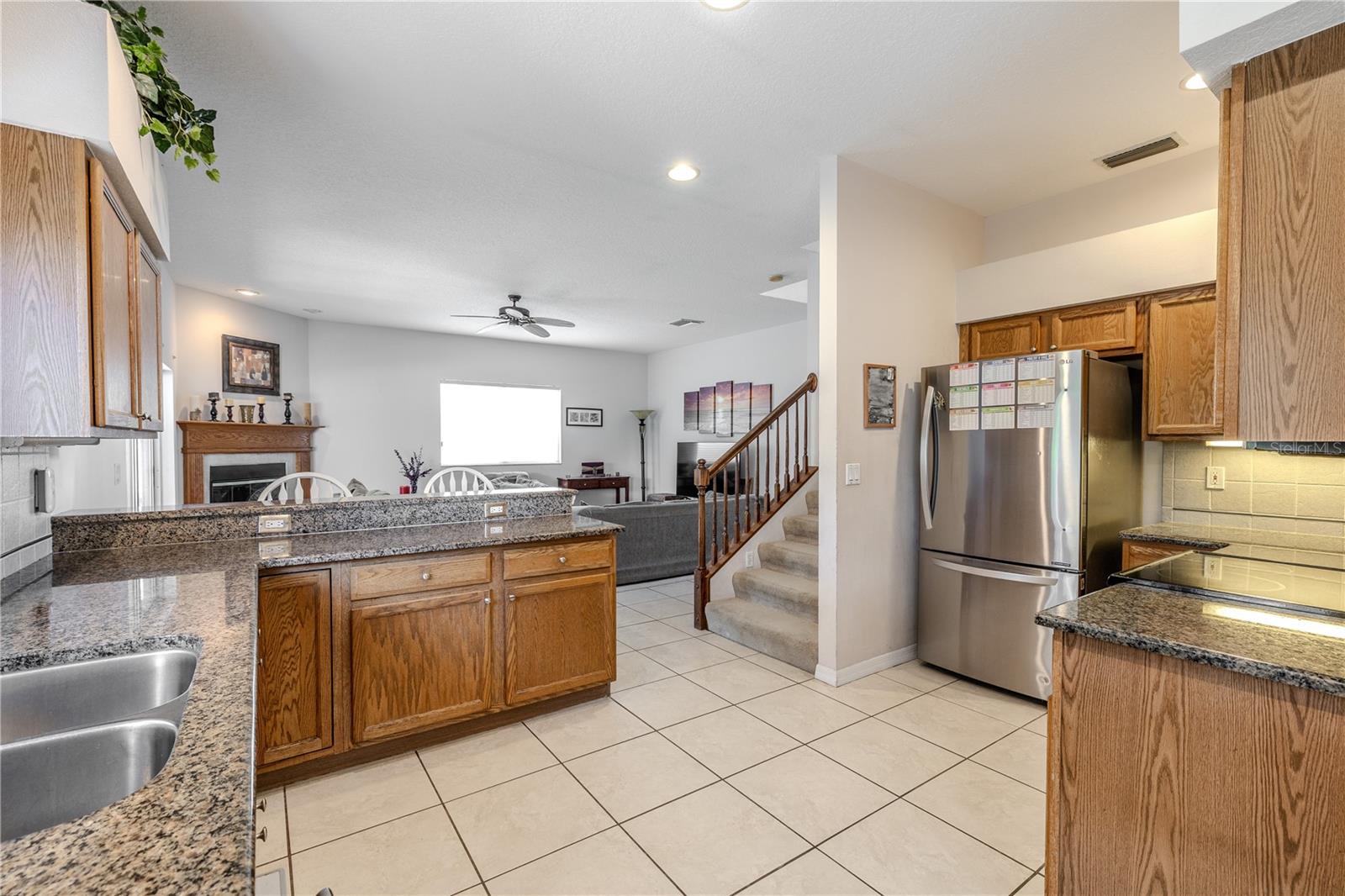 Entertain with ease in this open kitchen featuring granite countertops, stainless appliances, and a large breakfast bar that flows seamlessly into the spacious family room.