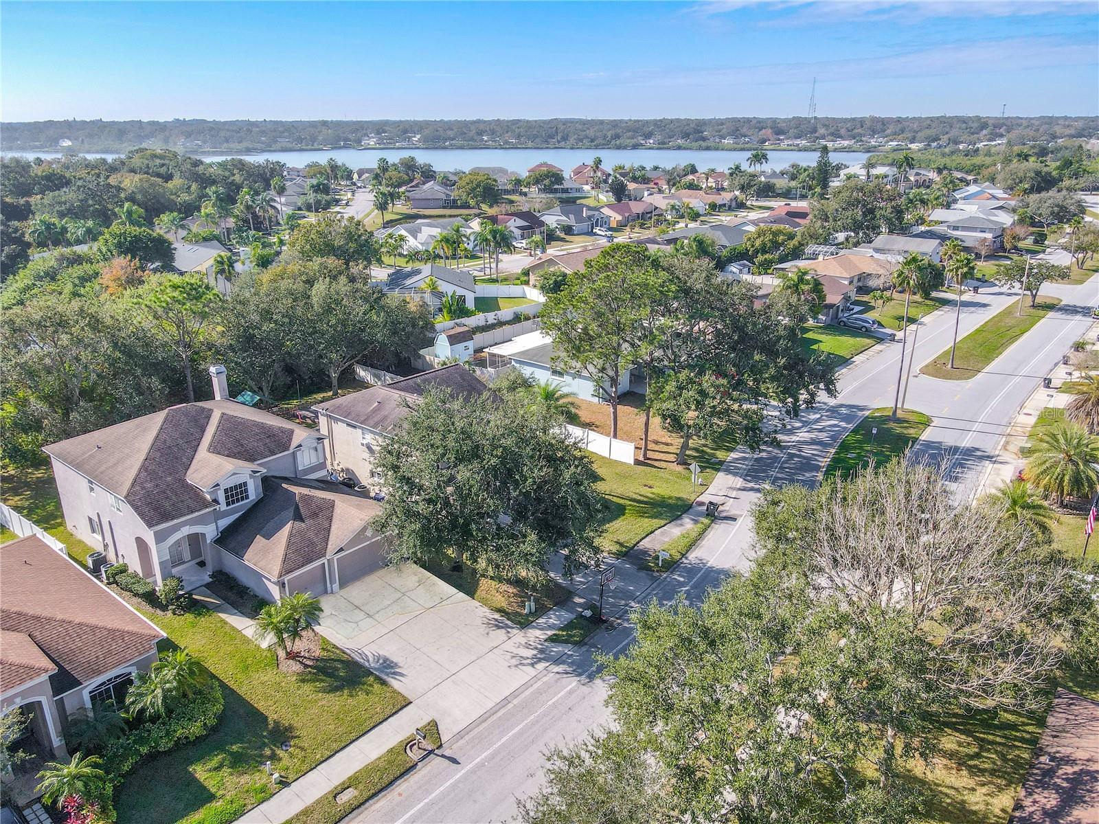 Aerial view highlights the home’s desirable neighborhood setting with mature trees, wide streets, and close proximity to the waterfront for a true Florida lifestyle.