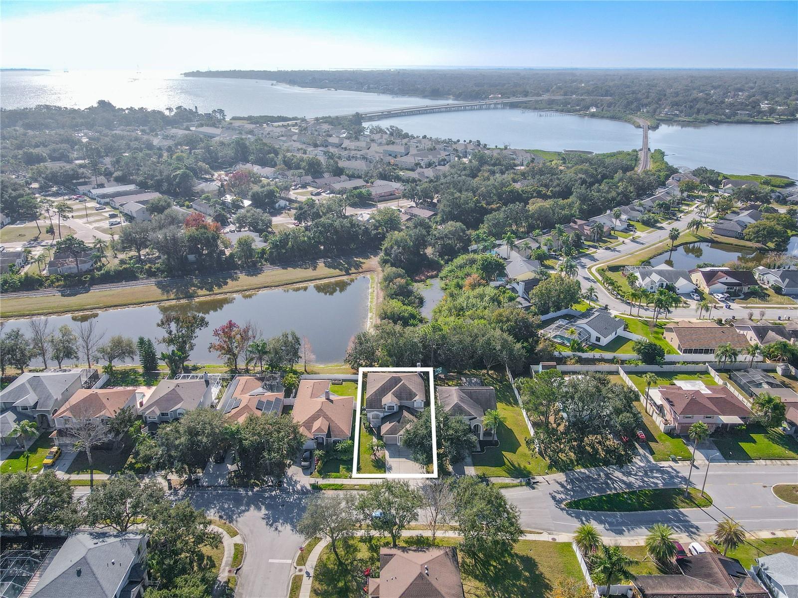 Aerial view showcases the home’s prime location near scenic waterways and neighborhood lakes, offering a peaceful setting just minutes from the bay.