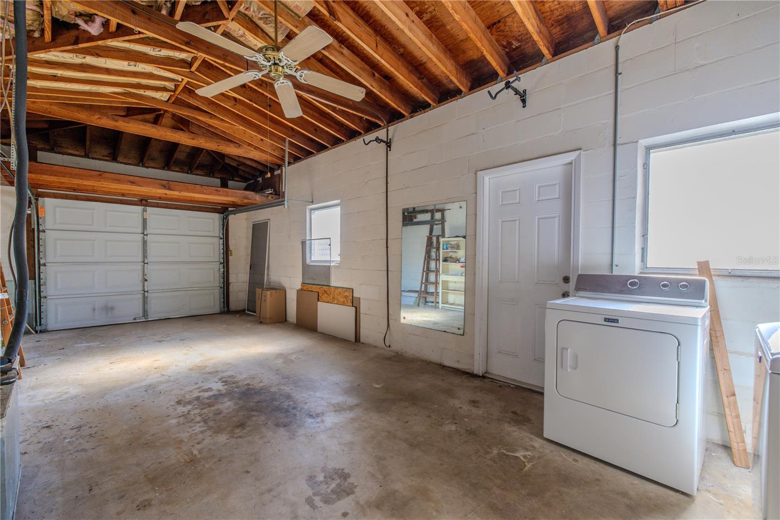 Spacious one-car garage with high open rafters, laundry area, and plenty of room for storage, hobbies, or a workshop, plus direct access into the home.