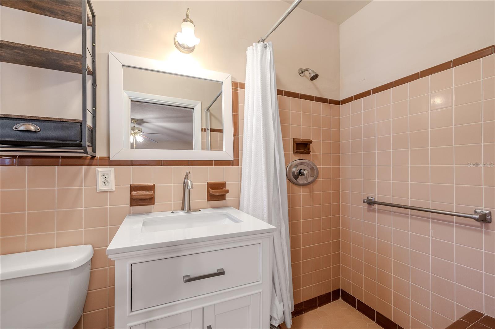 Additional primary en-suite bath with a walk-in shower, updated vanity and fixtures, and classic tile work for a clean, functional space.