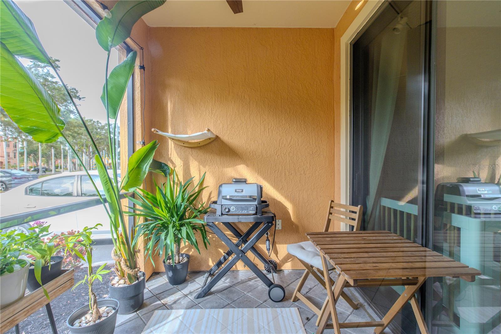 Private, covered patio ideal for morning coffee or evening grilling, framed by tropical greenery and offering a cozy outdoor retreat just off the living space.